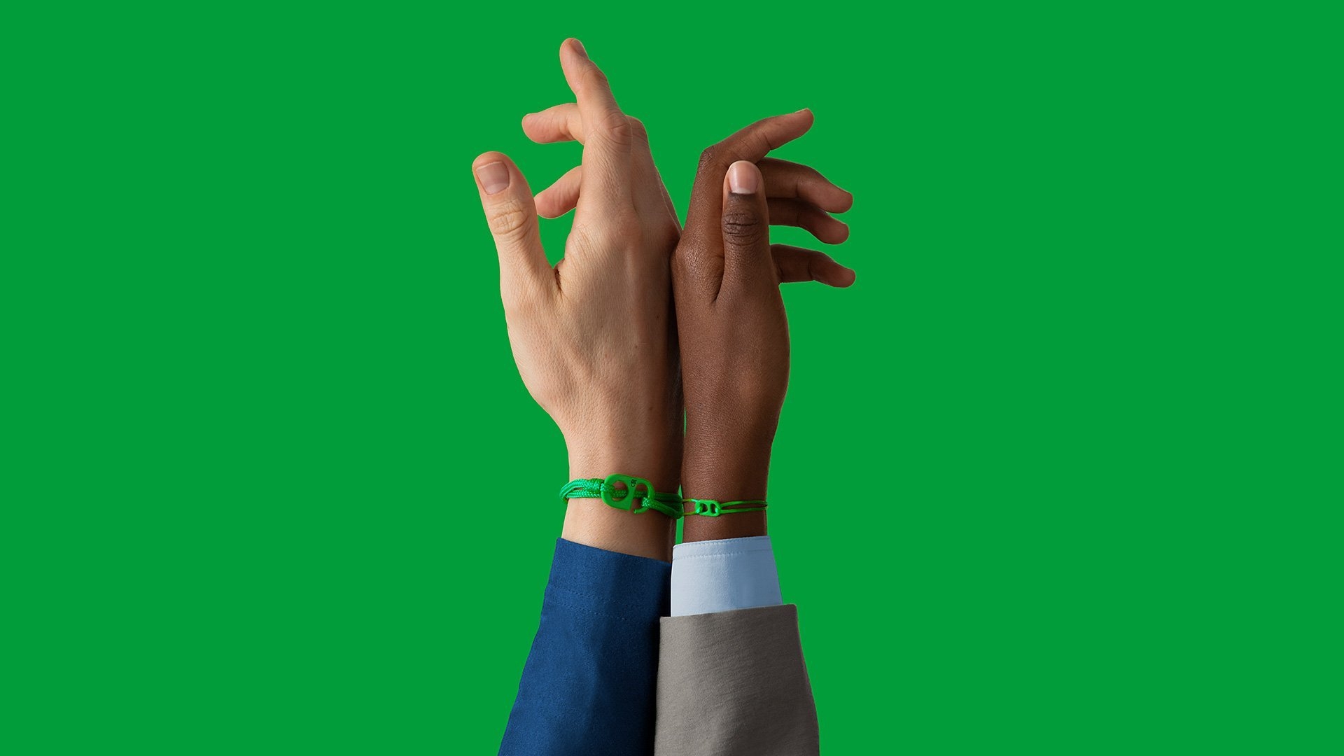 Two hands on a green background wearing #TOGETHERBANDs