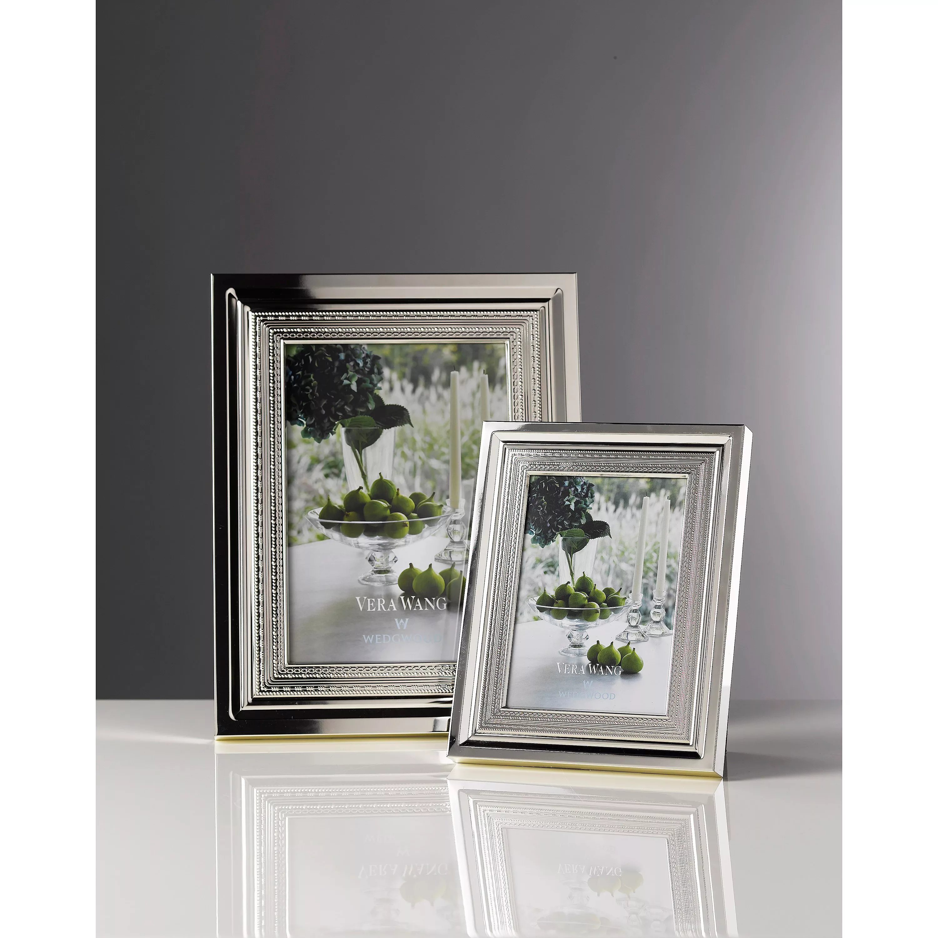 Vera Wang Wedgwood silver photo frames with beaded border, one large and one small, on reflective surface.