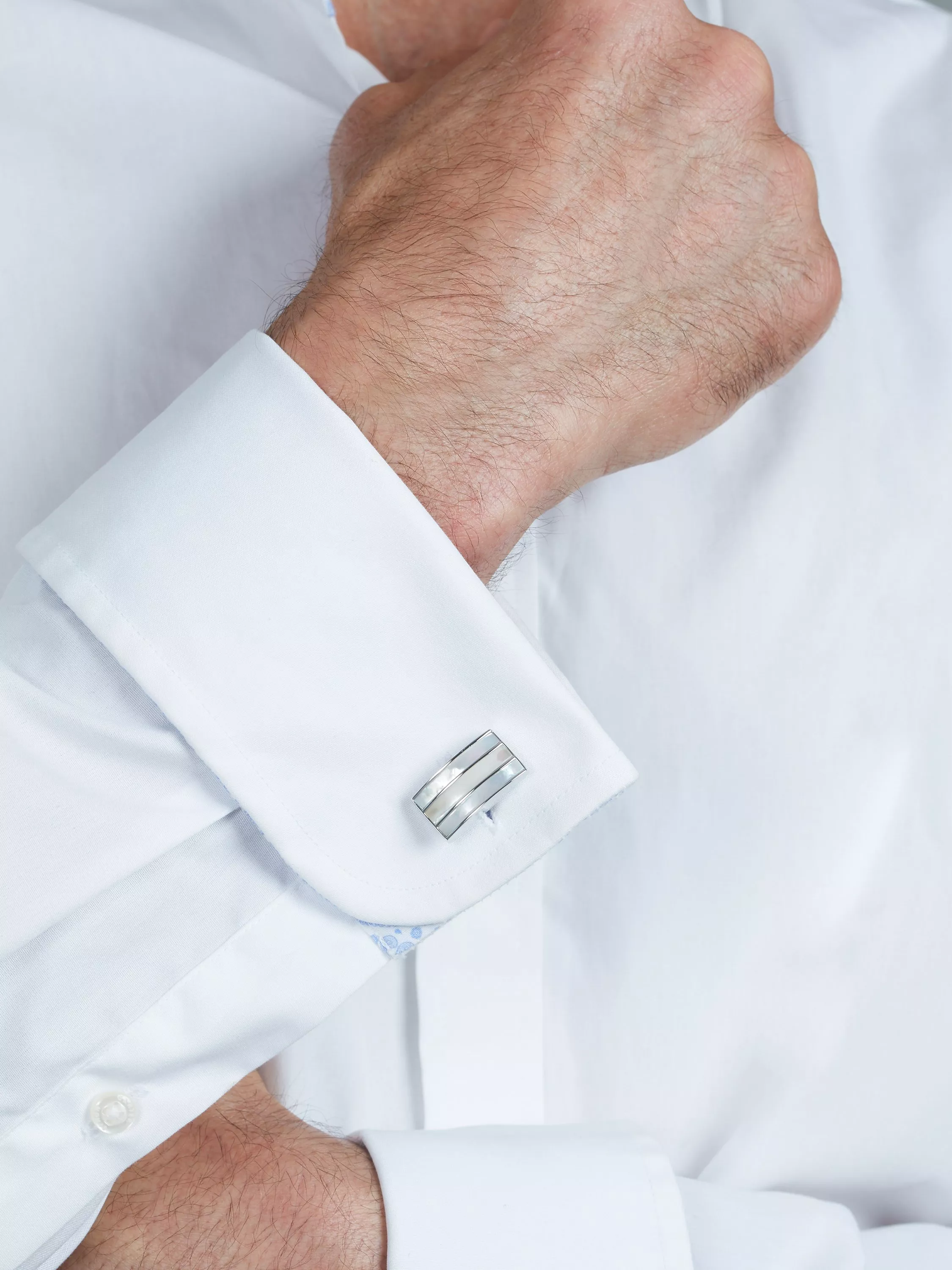 Man with cufflinks in his buttonholes