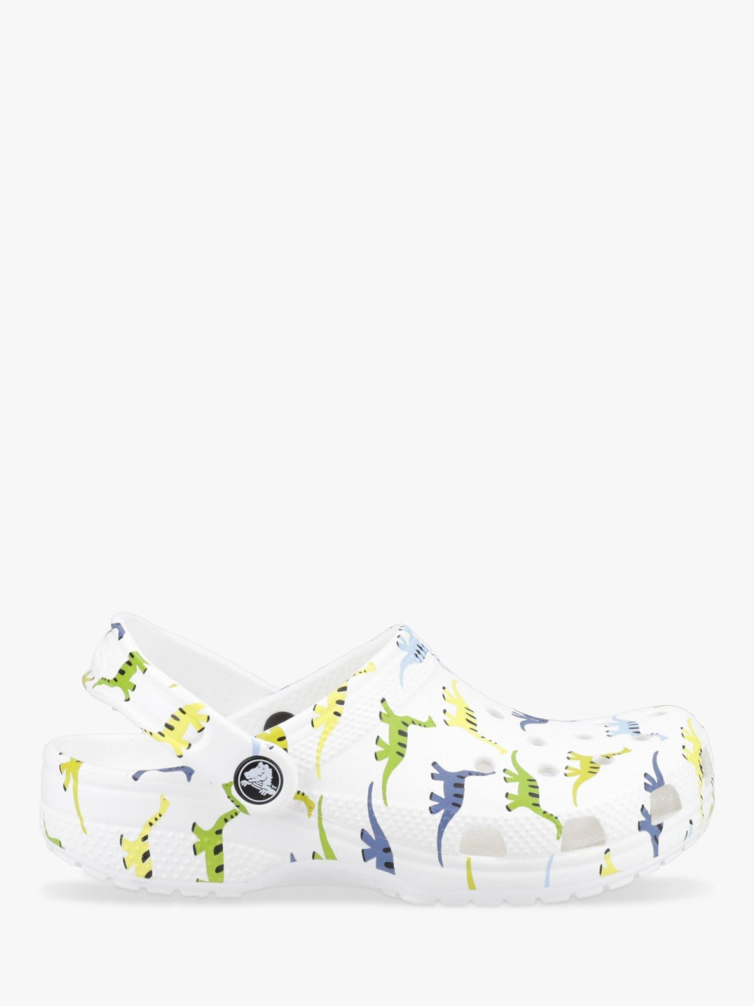 Product image 1 of 4, which shows Crocs Kids' Classic Croc Dino Print Clogs, White/Multi, 11 Jnr