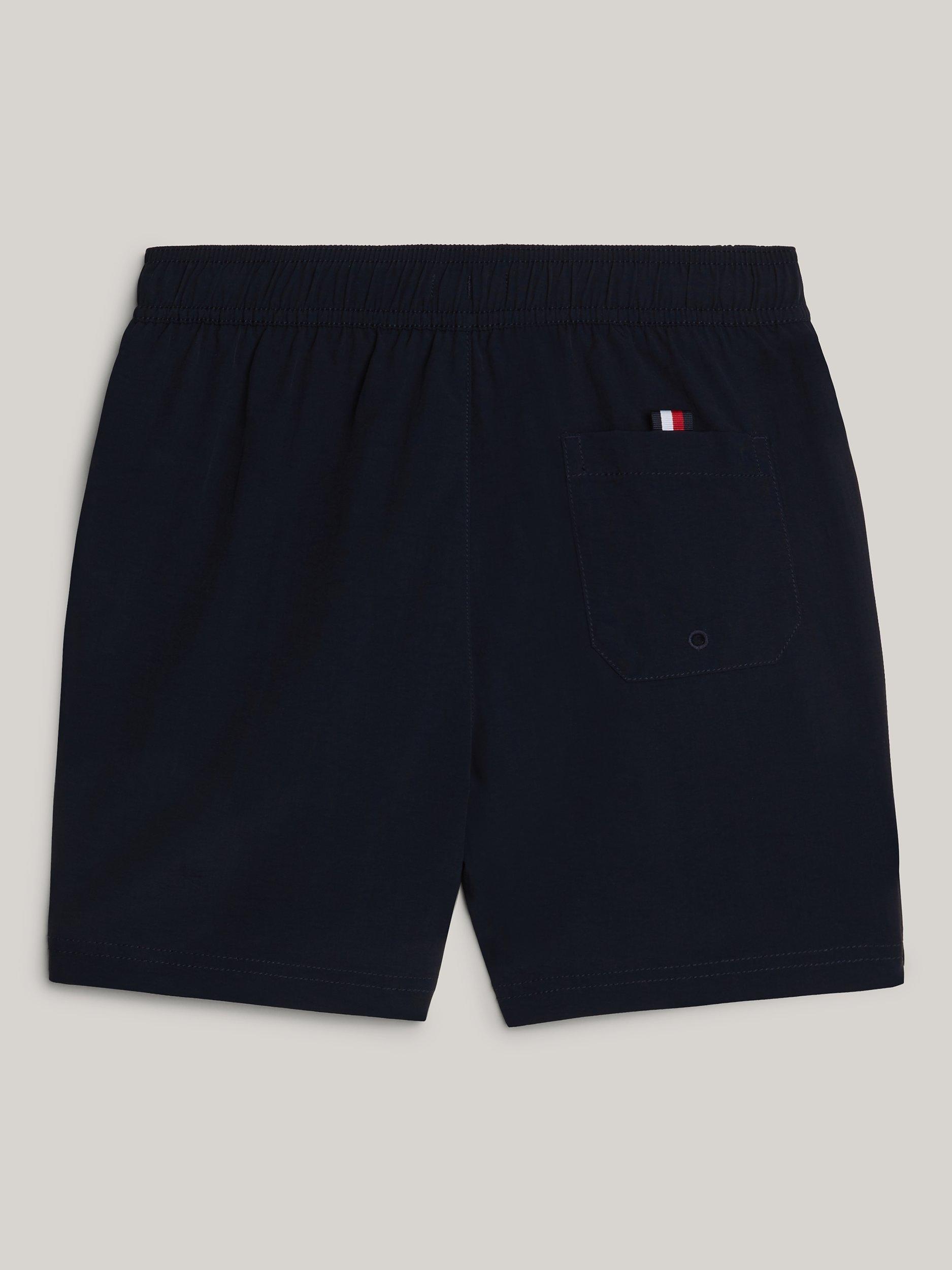 Product image 2 of 3, which shows Tommy Hilfiger Kids' Logo Flag Medium Drawstring Swim Shorts, Desert Sky, 10-12 years