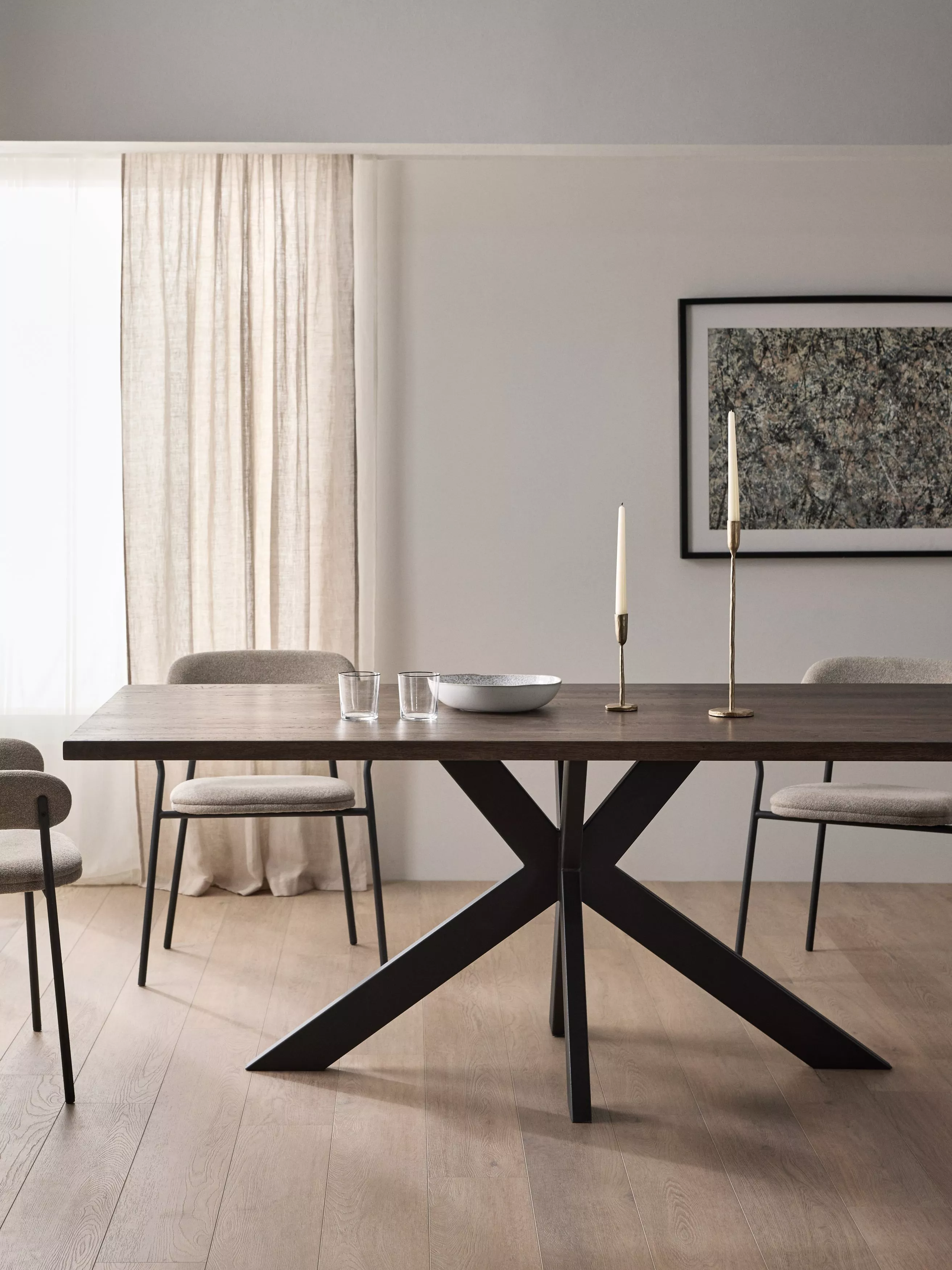 Modern dining room with dark wood table, upholstered chairs, abstract wall art and herringbone fireplace detail