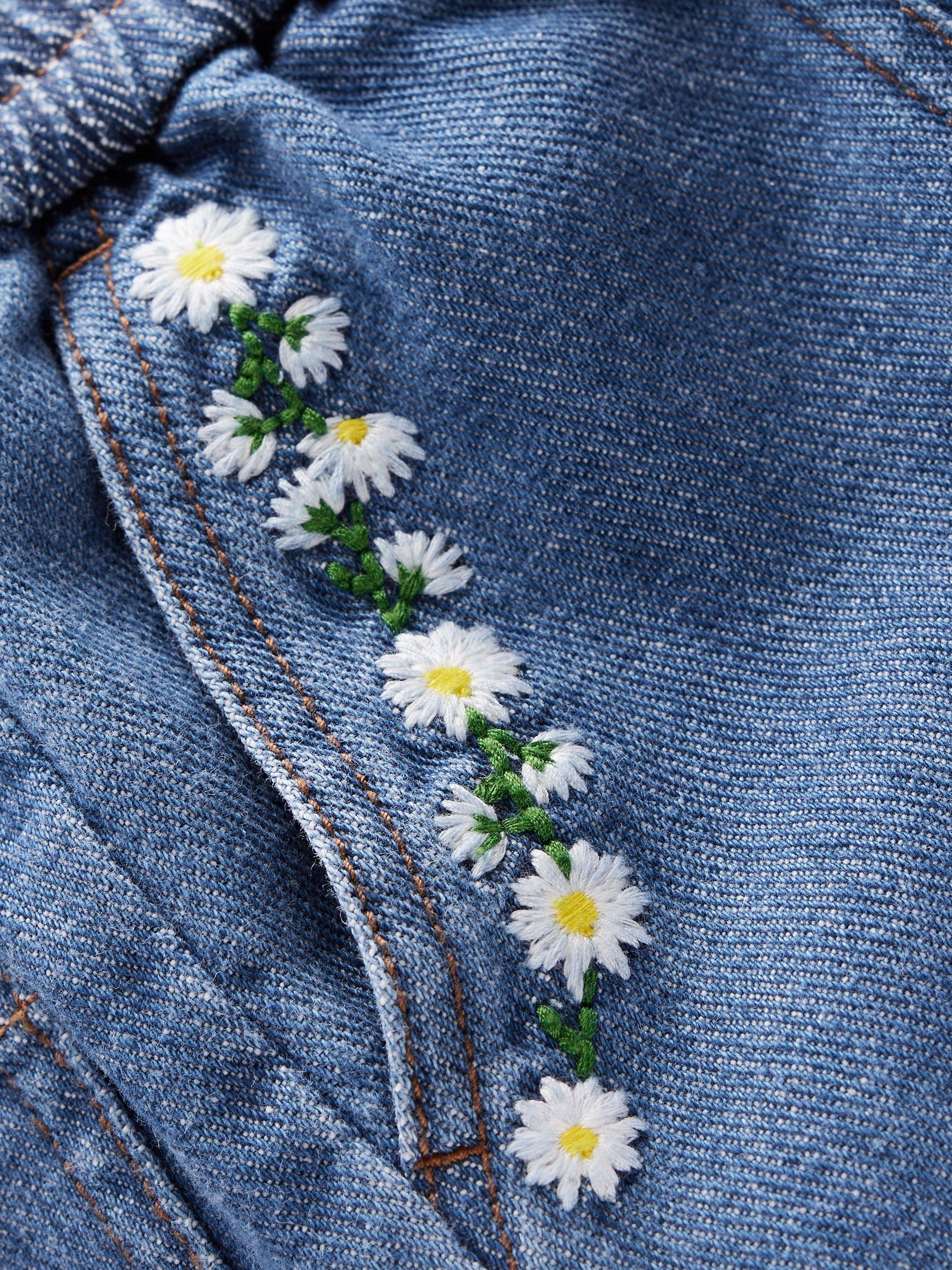 Product image 3 of 3, which shows Mini Boden Girl's Daisy Pocket Pull-On Denim Trousers, Embroidered Daisy, 2-3 years