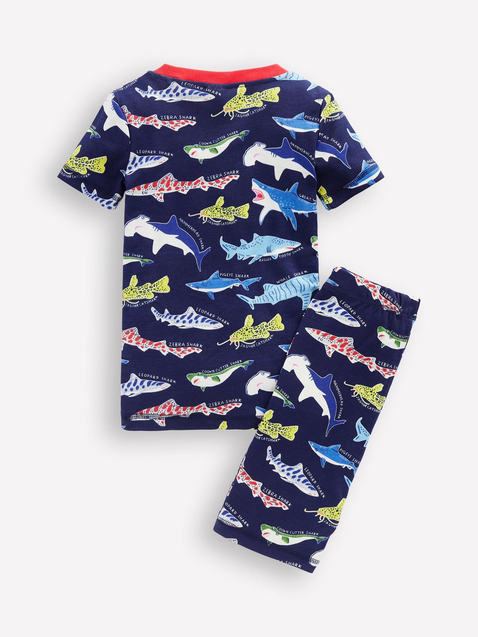 Product image 2 of 3, which shows Mini Boden Kids' Cotton Glow-in-th-Dark Short John Pyjamas, College Navy Sharks, 2 years
