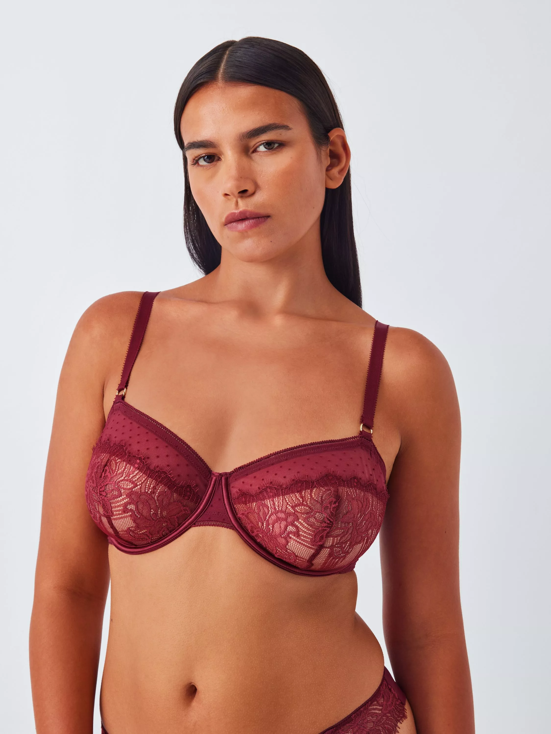 Model wearing burgundy lace underwired bra, fashion lingerie studio portrait on a light background