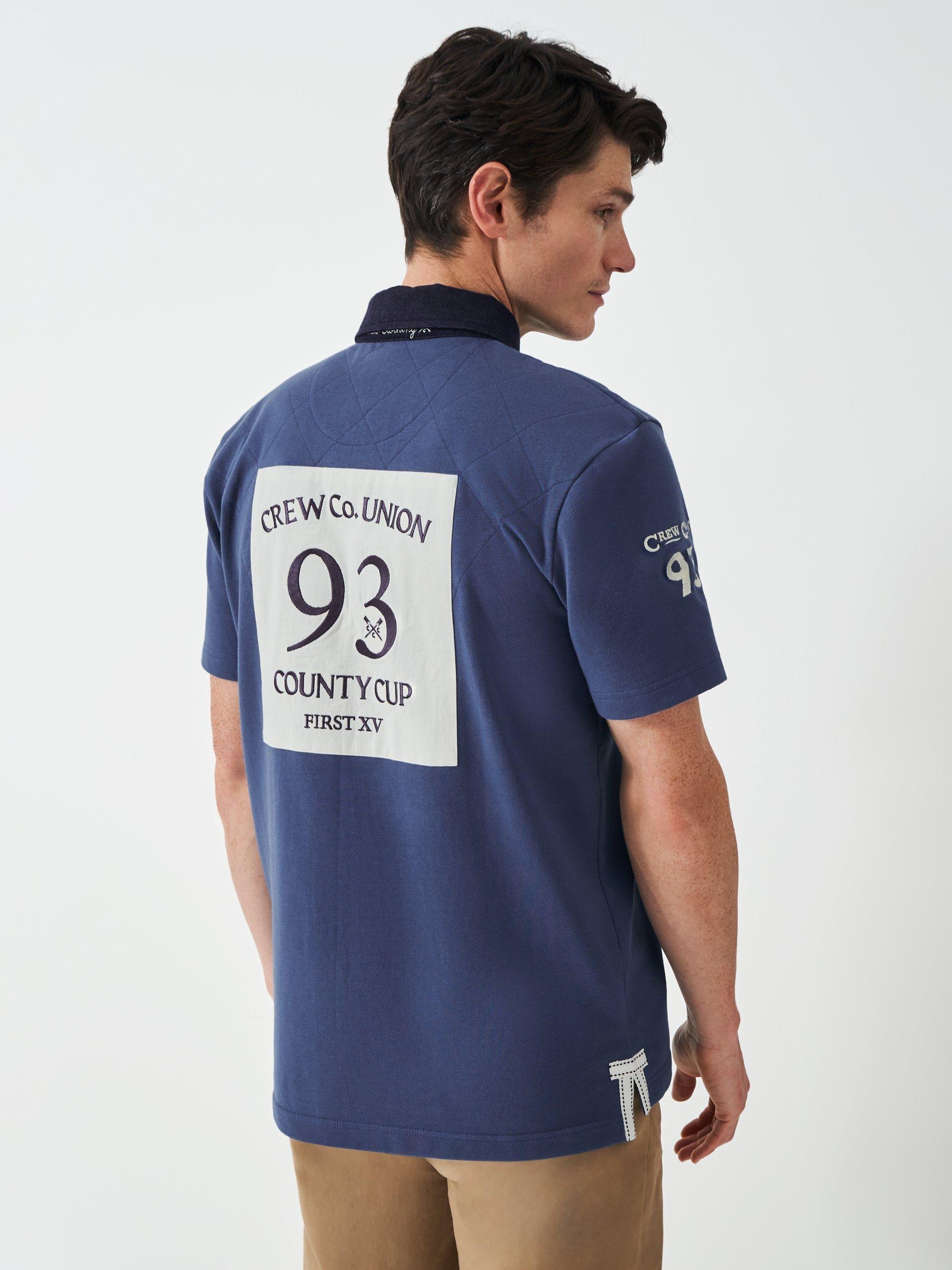 Product image 4 of 6, which shows Crew Clothing Patchwork Short Sleeve Cotton Polo Shirt, Dark Blue, L