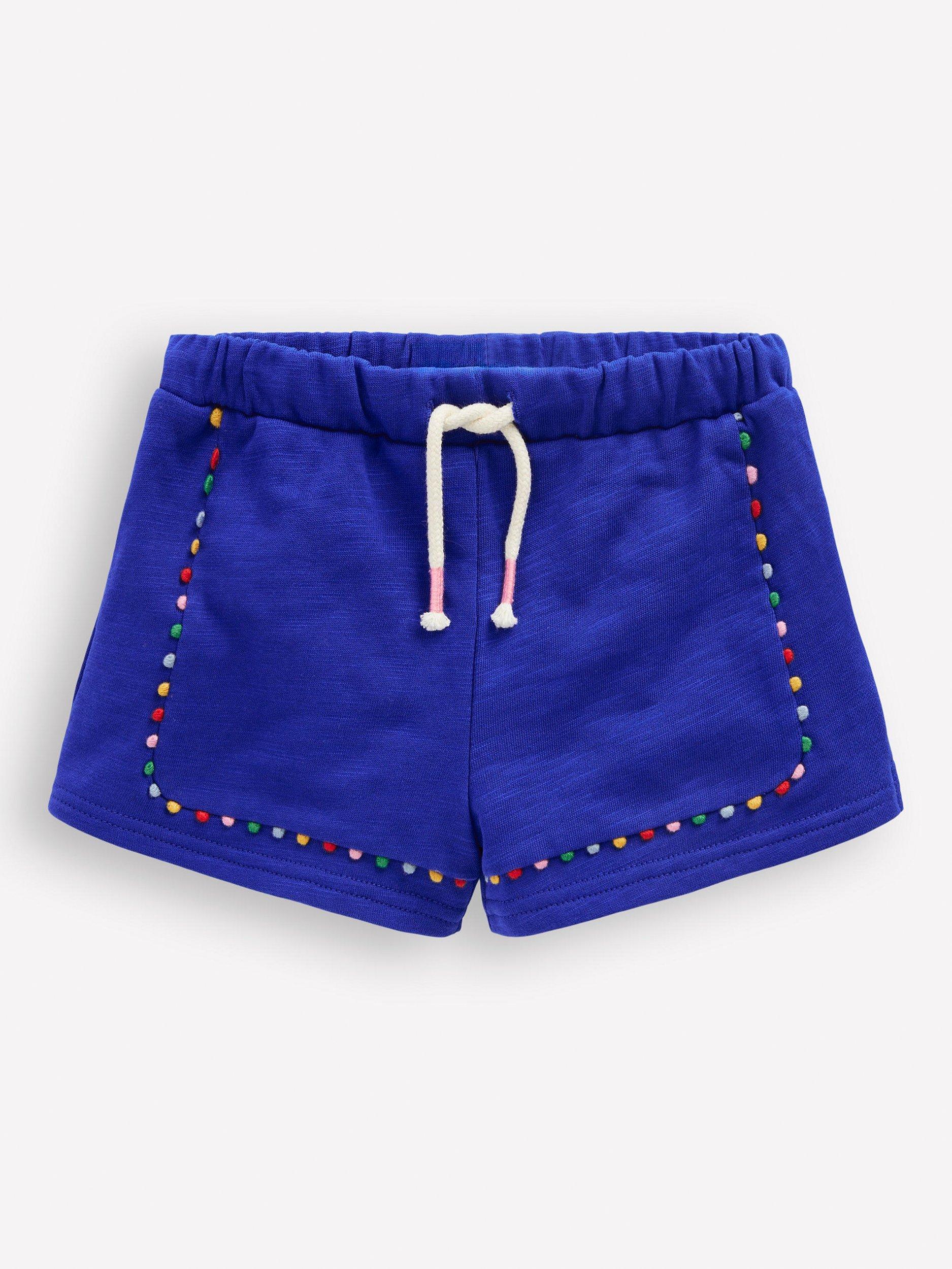 Product image 1 of 3, which shows Mini Boden Kids' Cotton Pom-Pom Trim Jersey Shorts, Bright Blue, 3-4 years