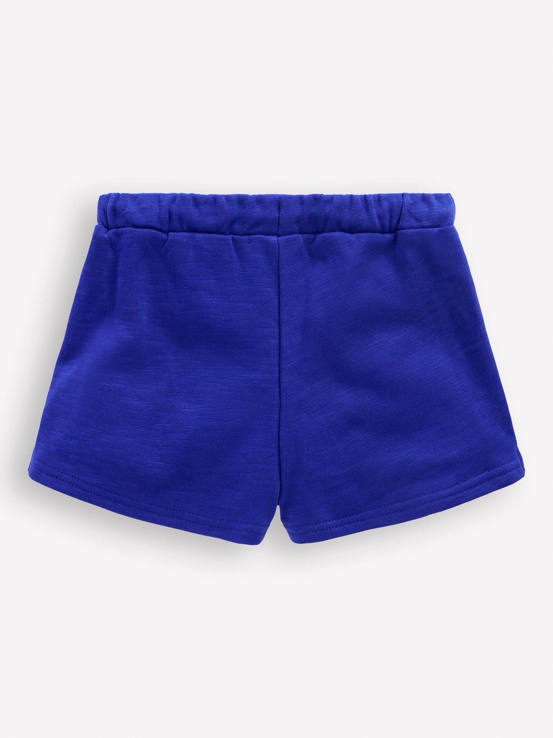 Product image 2 of 3, which shows Mini Boden Kids' Cotton Pom-Pom Trim Jersey Shorts, Bright Blue, 3-4 years