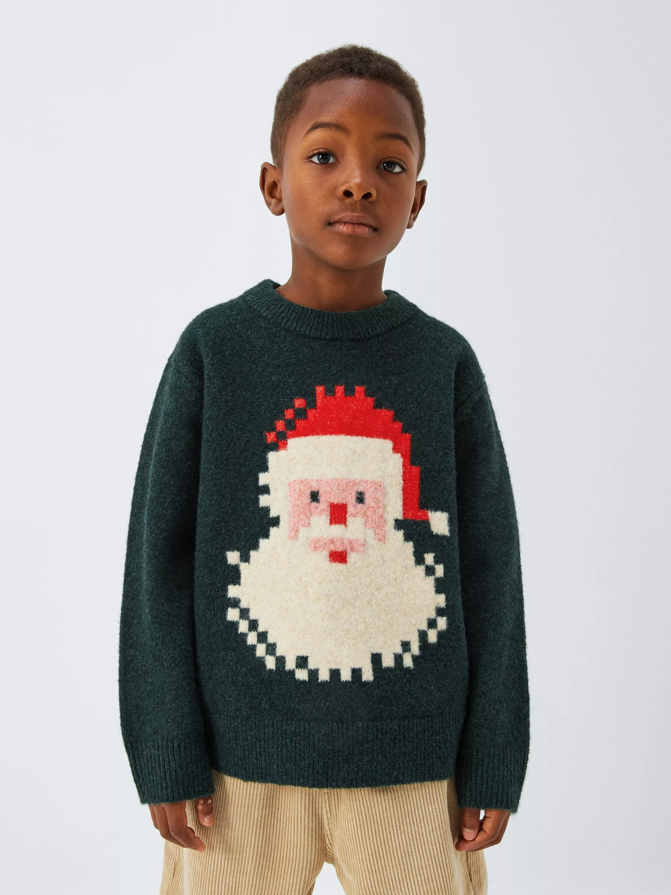 boy wearing a Christmas jumper with a pixelated Santa face on it