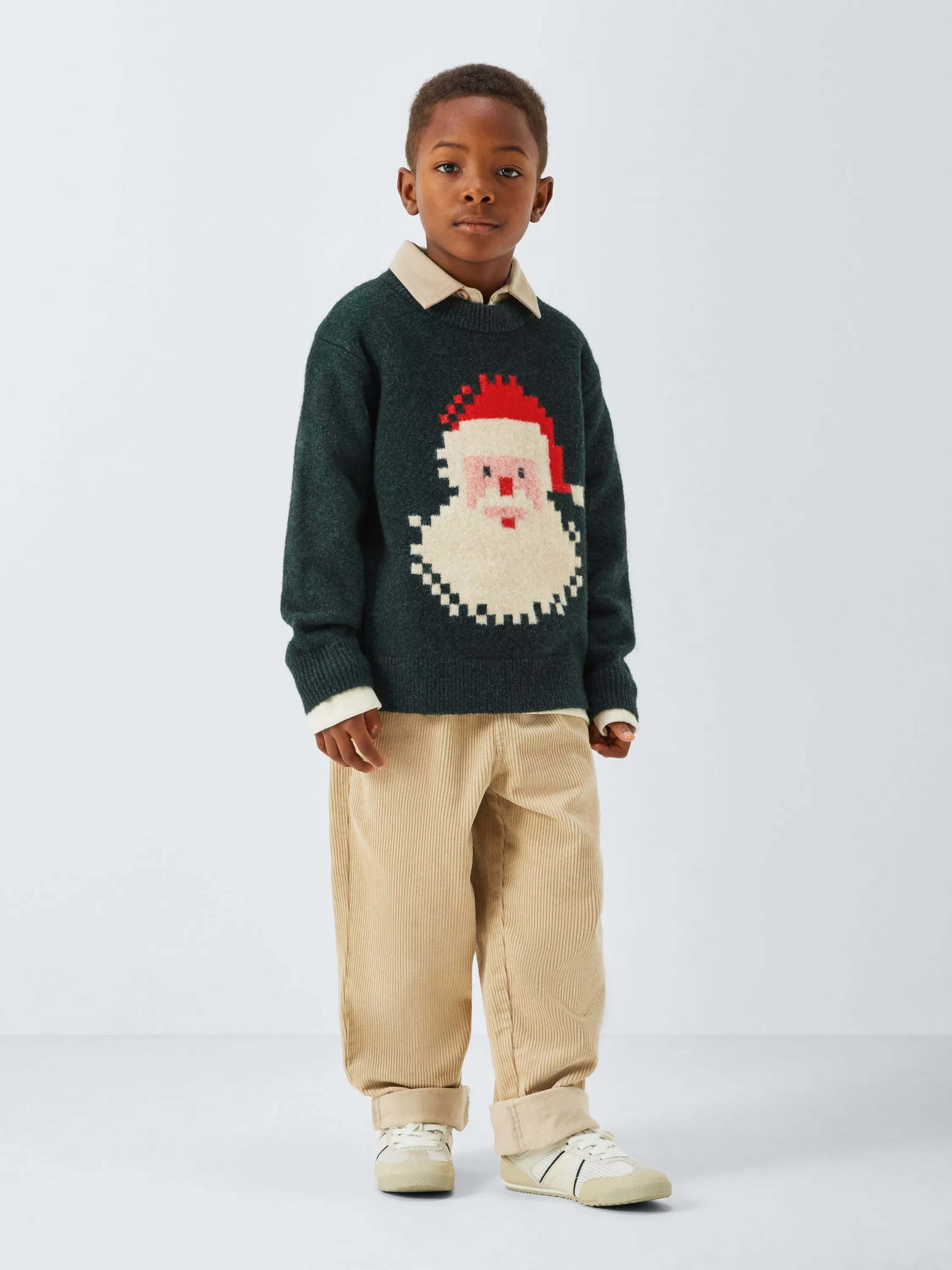 boy wearing a Christmas jumper with a pixelated Santa face on it