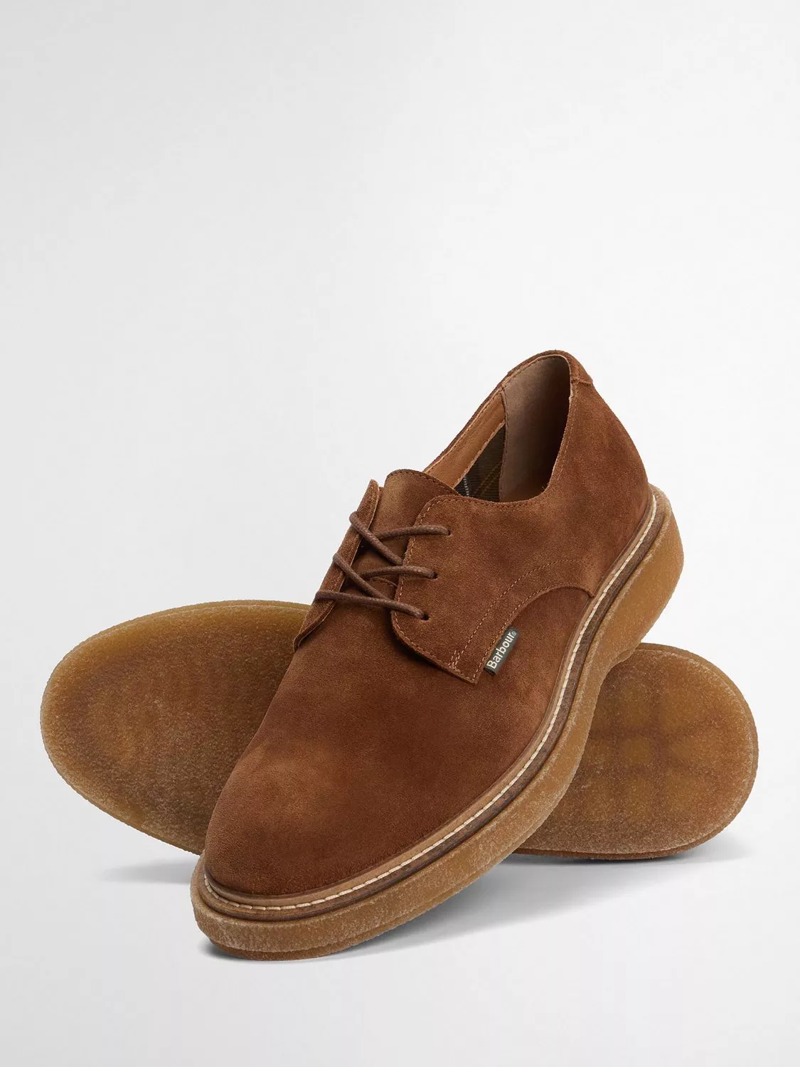 Brown suede derby shoes with lace-up front and crepe sole, studio product photo on white background