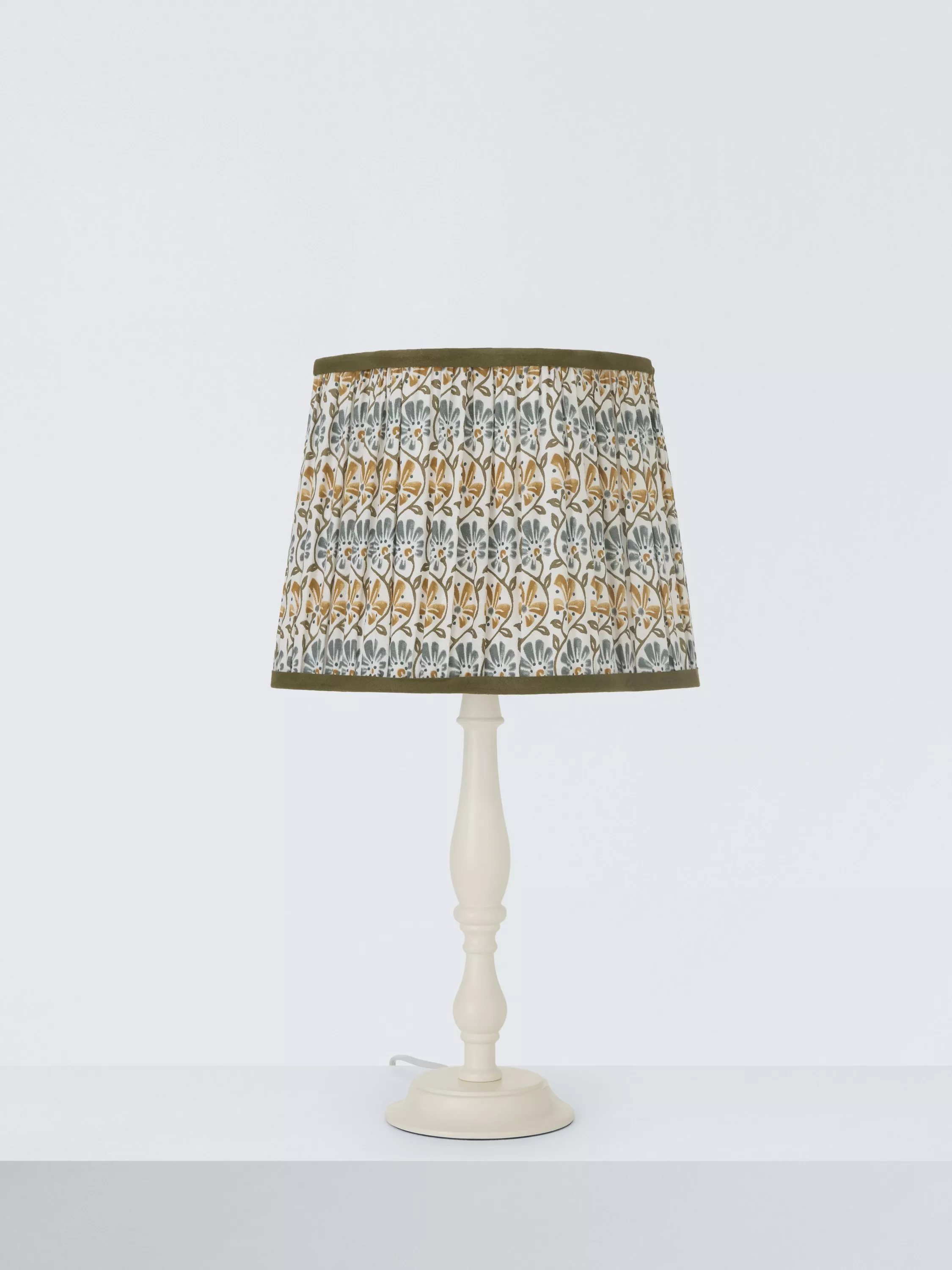 A model wears a stylish dark corduroy jacket with matching trousers, showcasing a chic and minimalist fashion look.