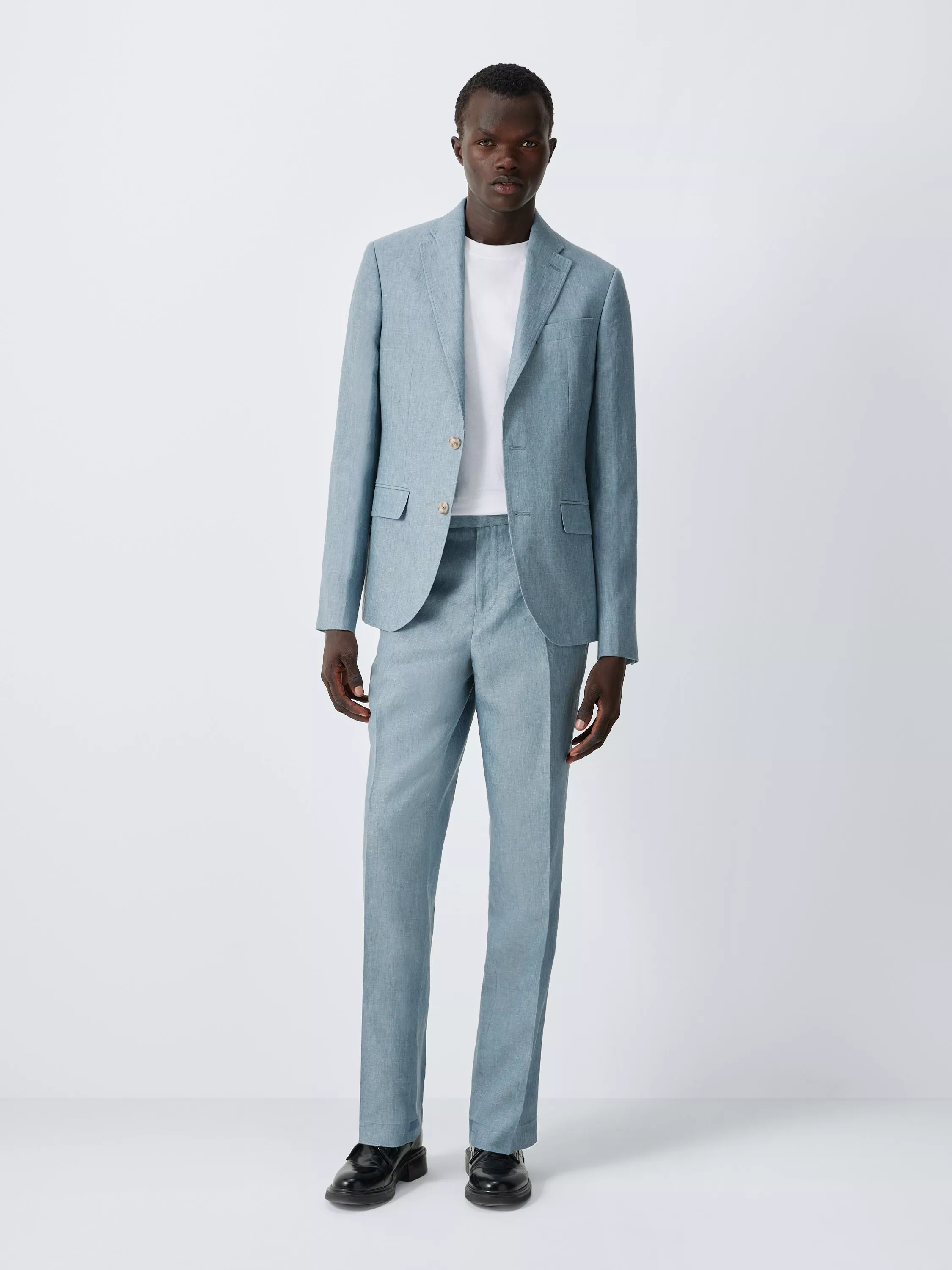 Men’s light blue tailored suit with single-breasted blazer and trousers, worn over a white T-shirt on grey background