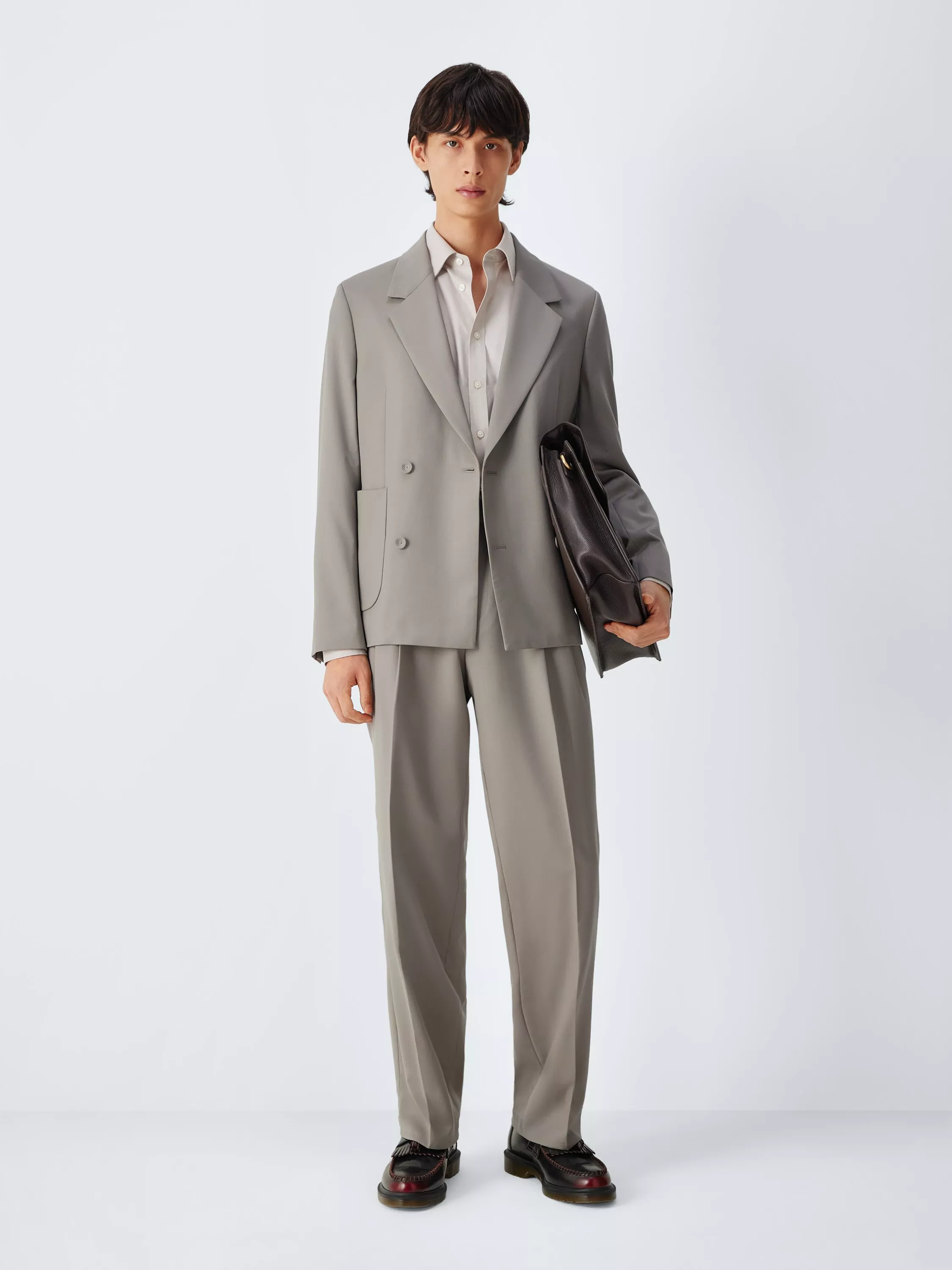 Male model wearing a beige double-breasted linen blazer over a white T-shirt, studio fashion portrait