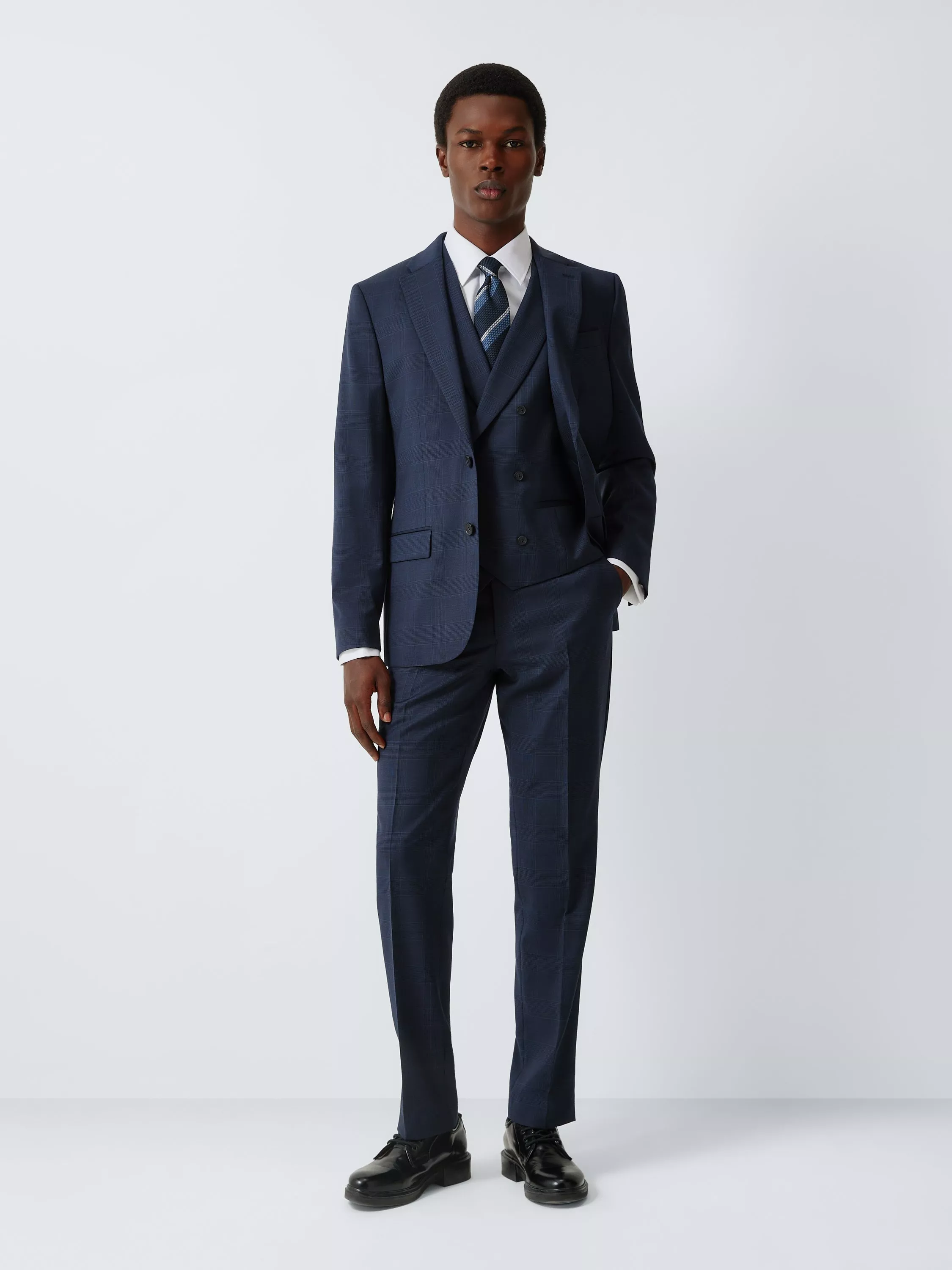 Male model wearing a light blue two-piece suit with white shirt and silver tie, front view on plain background
