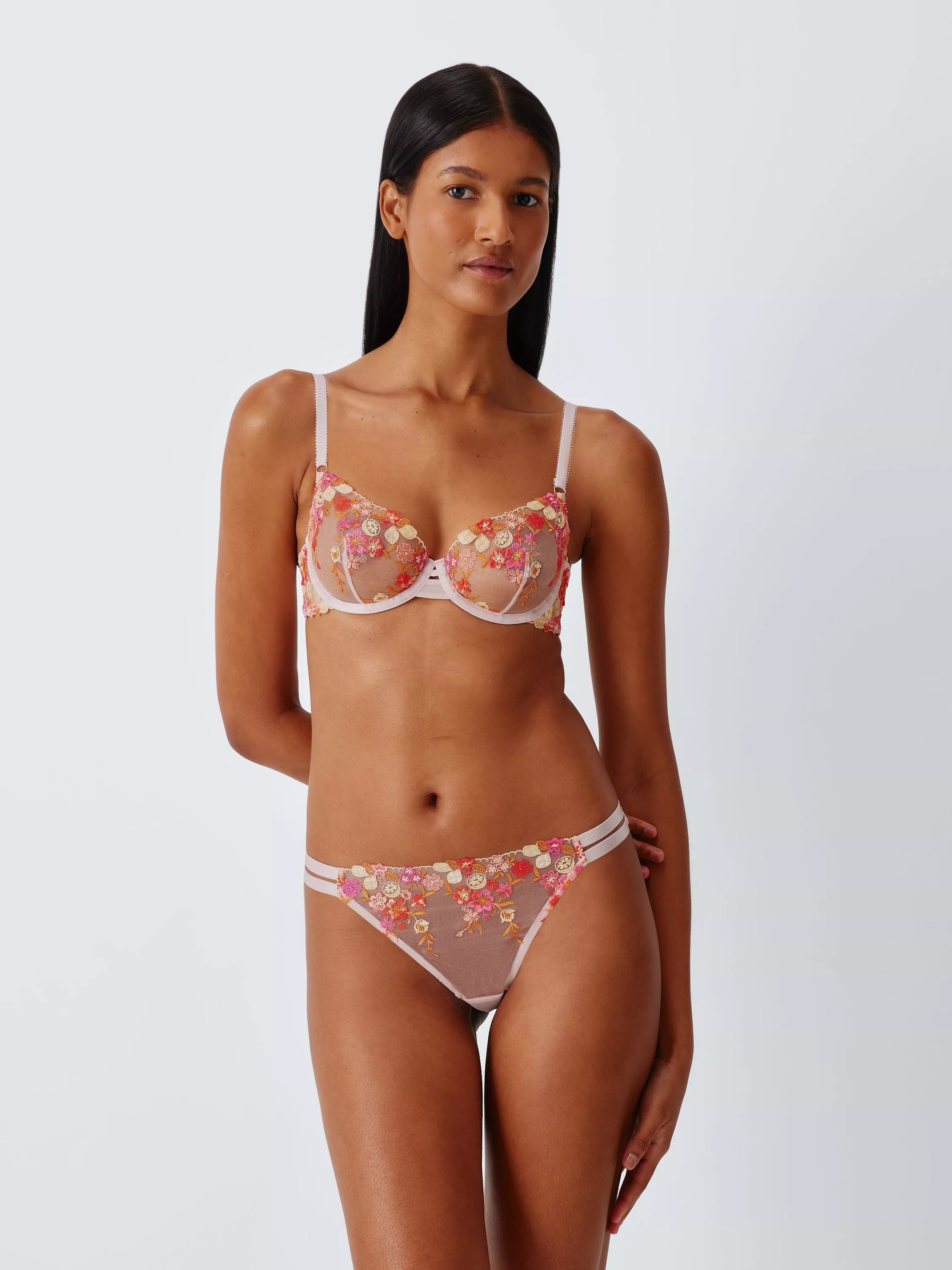 Model wearing floral embroidered mesh lingerie set with underwired bra and matching briefs on a white background