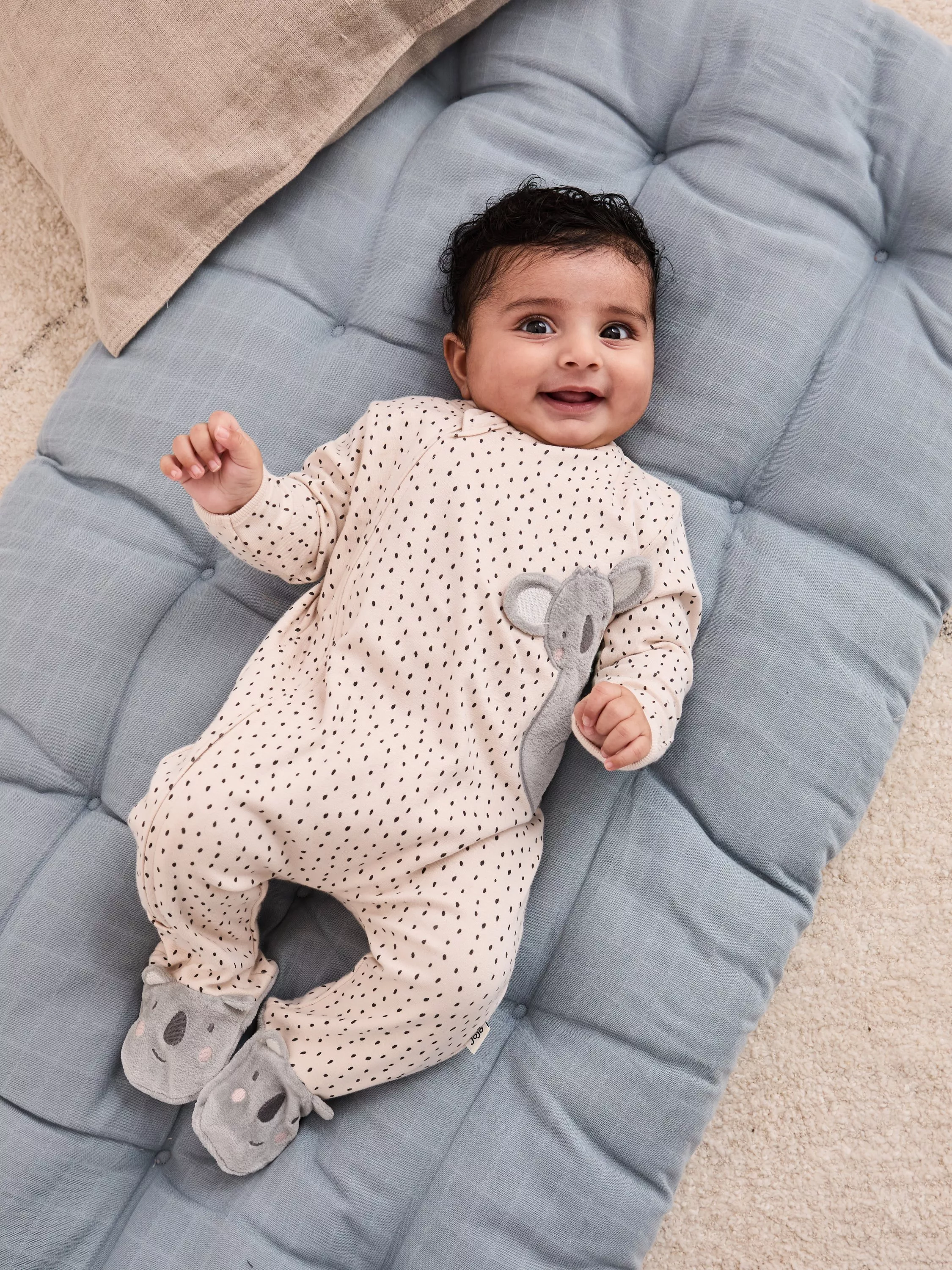 Baby girl in JoJo Maman Bébé polka dot sleepsuit