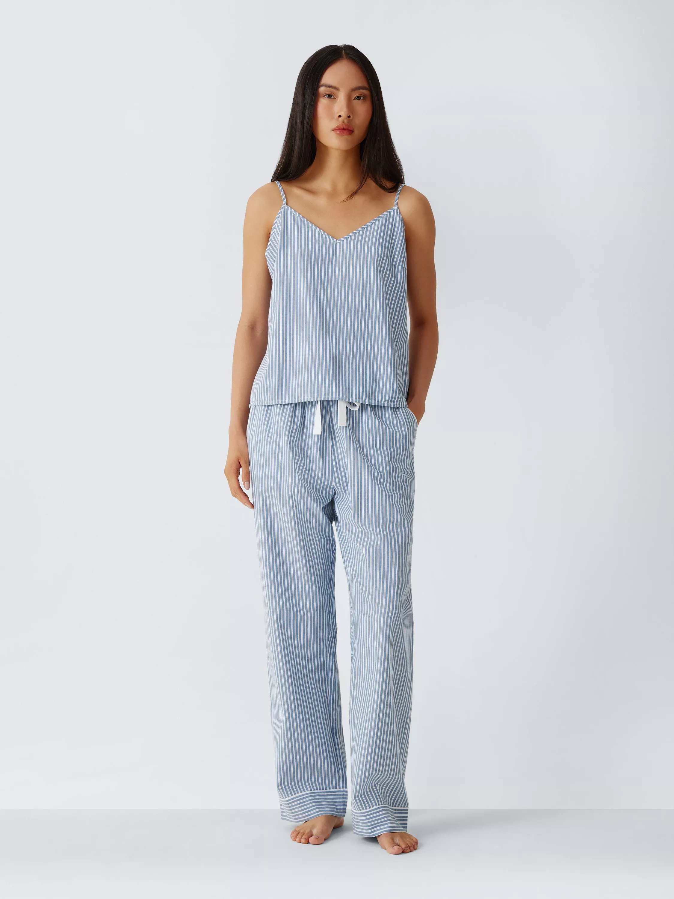 Model wearing blue and white striped camisole pyjama top with matching drawstring trousers, studio fashion shot