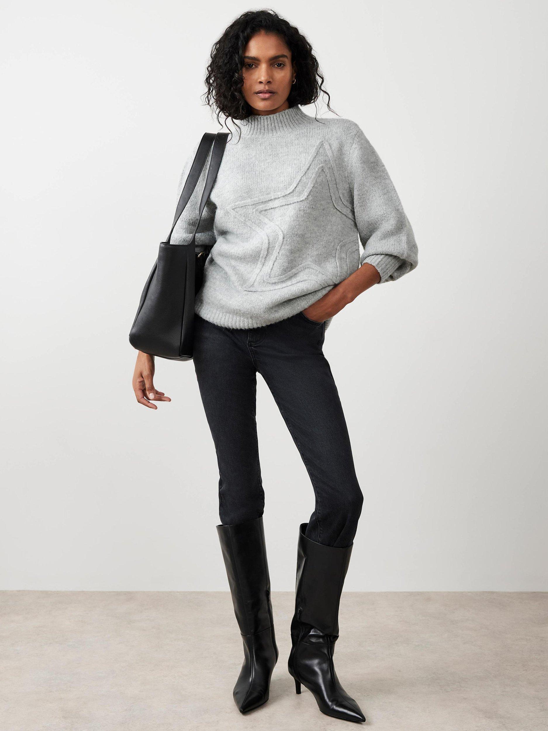 Woman in grey turtleneck sweater and black skinny jeans