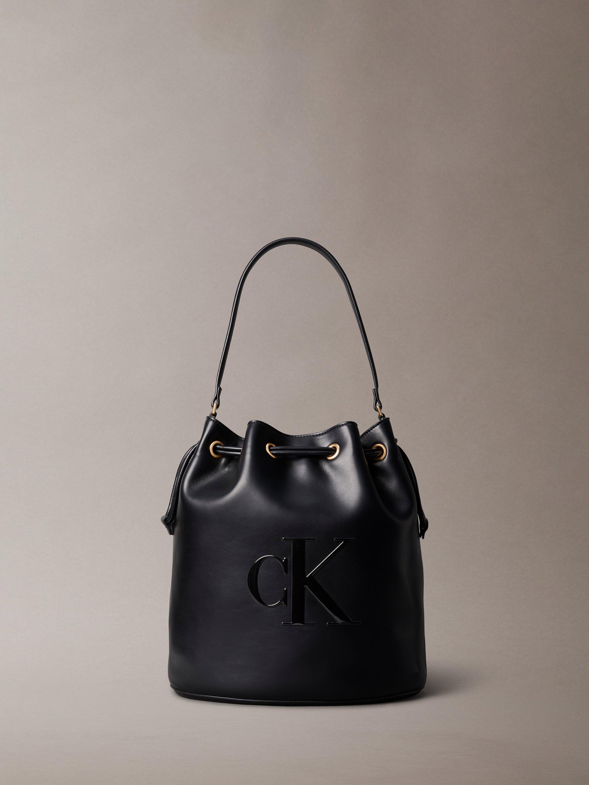 Product image 1 of 4, which shows Calvin Klein Sandi Embossed Monogram Logo Bucket Bag, Black, One Size
