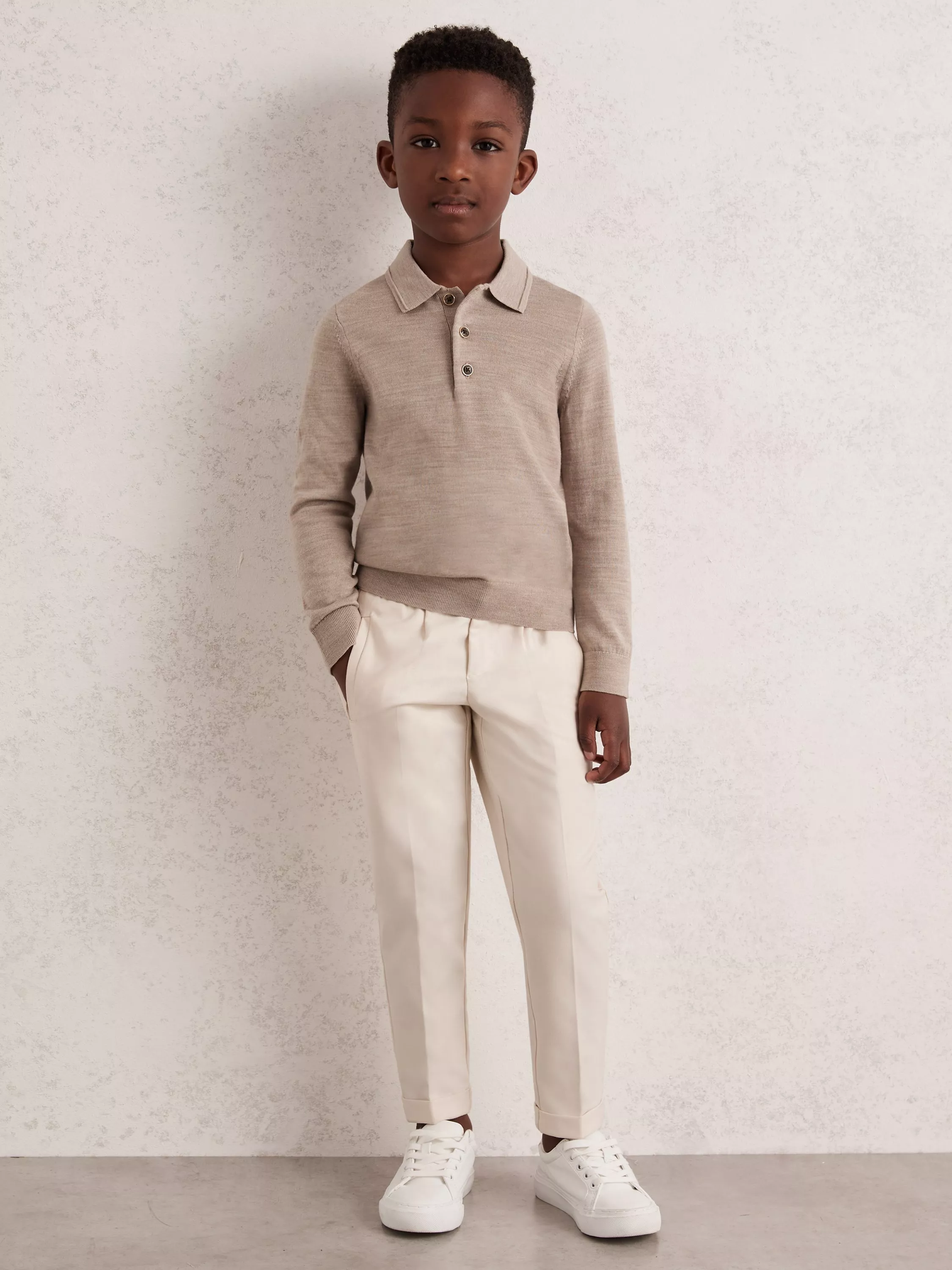 Boy in Reiss beige jumper and trousers