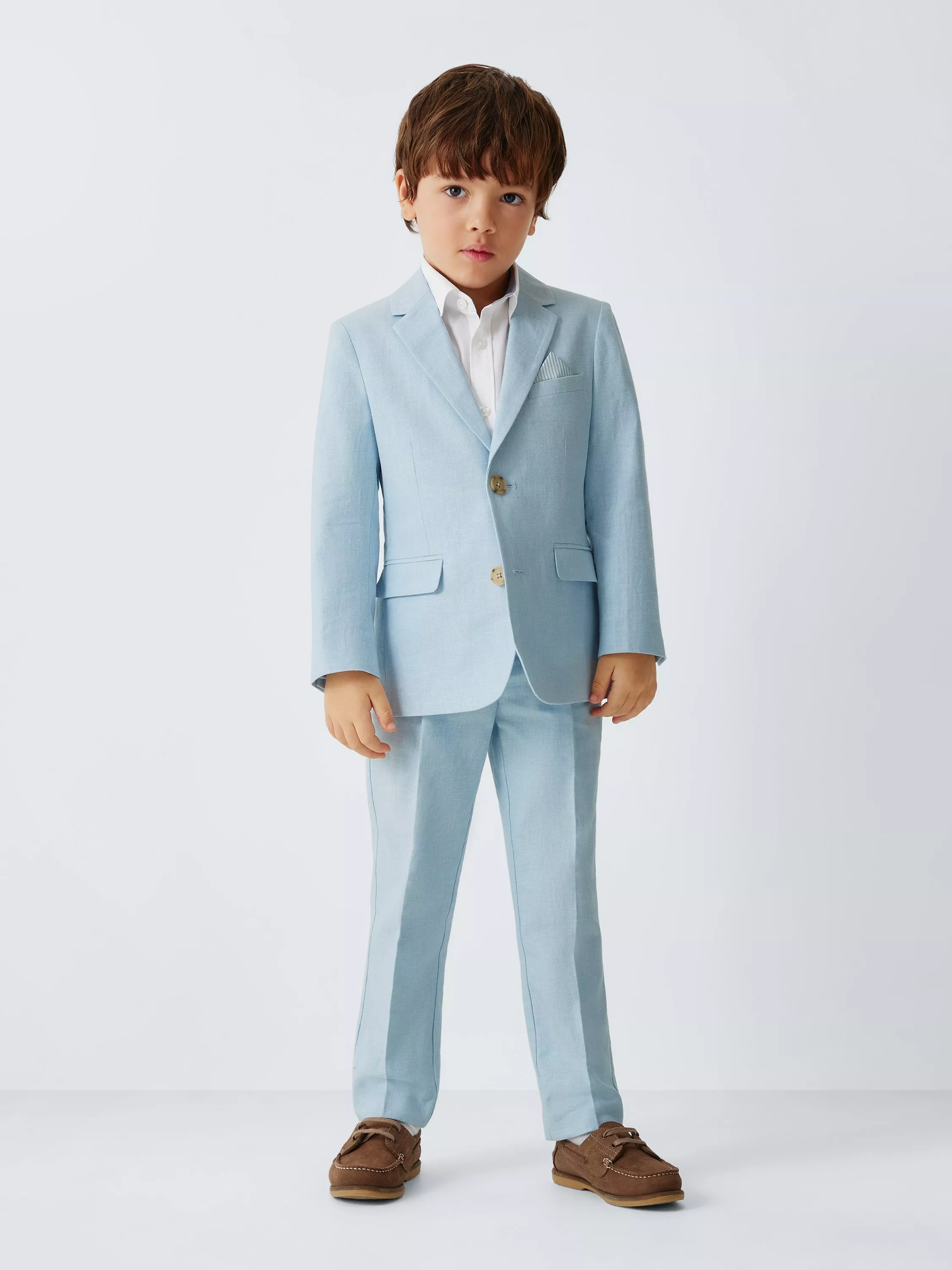 Young boy in a smart light blue suit with a white shirt, standing against a plain background.