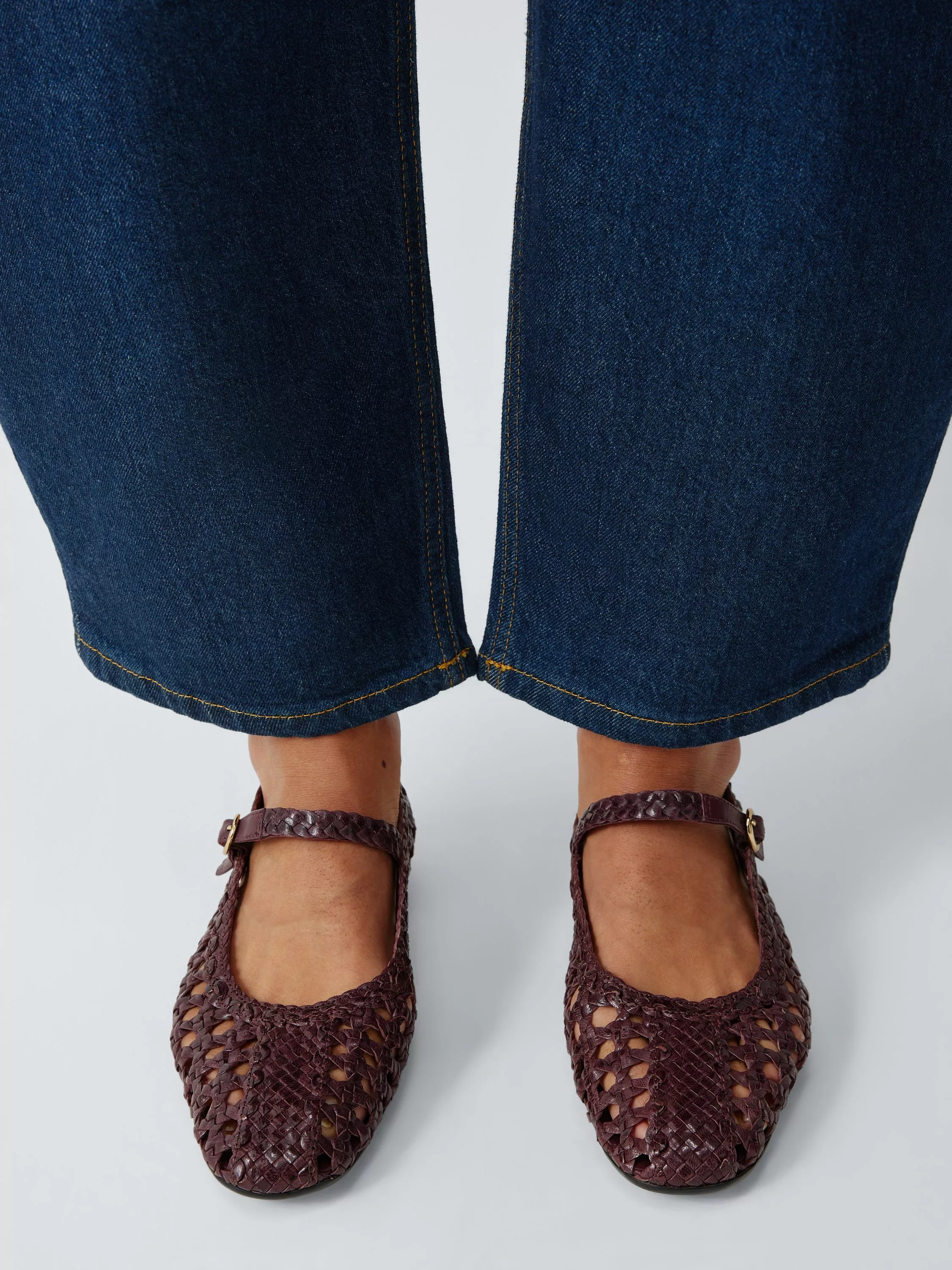 Stylish black leather loafers paired with dark leather trousers, showcasing modern fashion footwear.