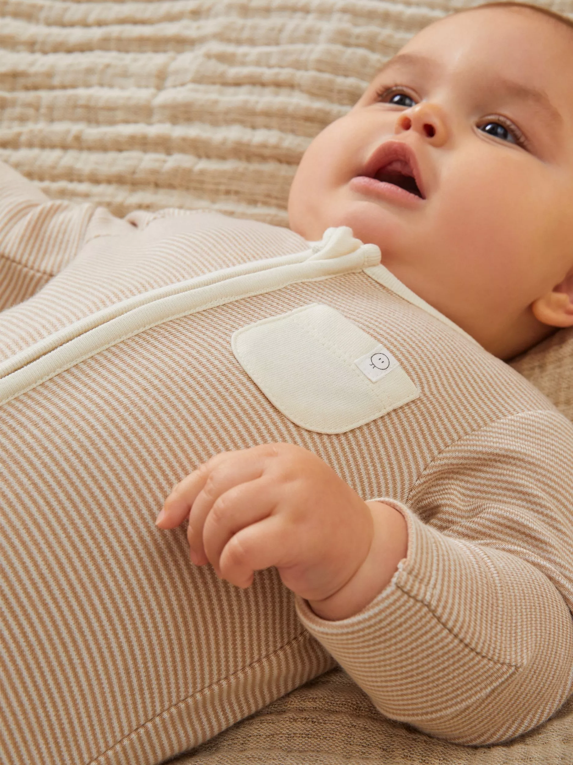 baby wearing a striped sleepsuit