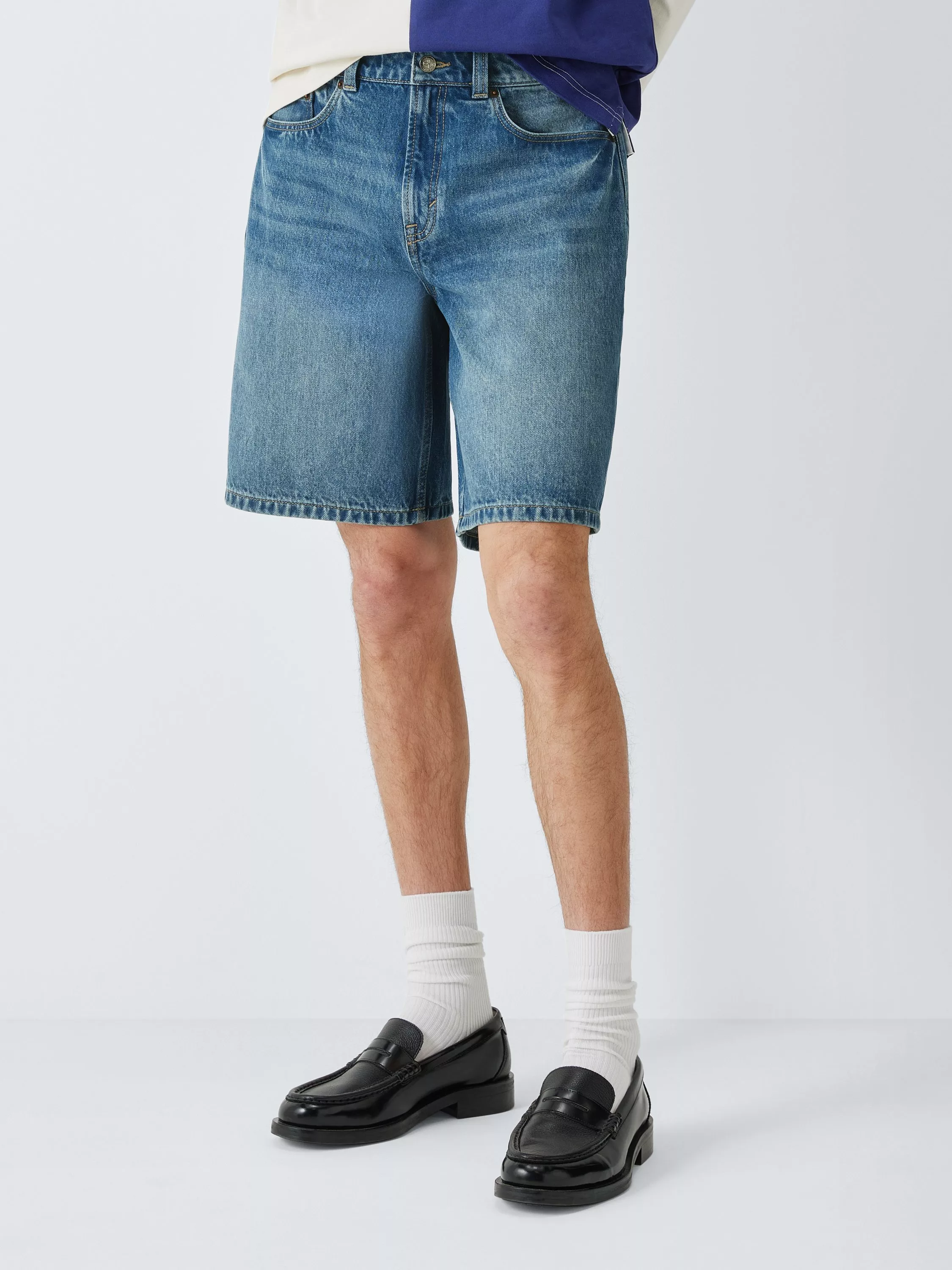 Men’s blue denim shorts with classic five-pocket design, styled with white socks and black loafers