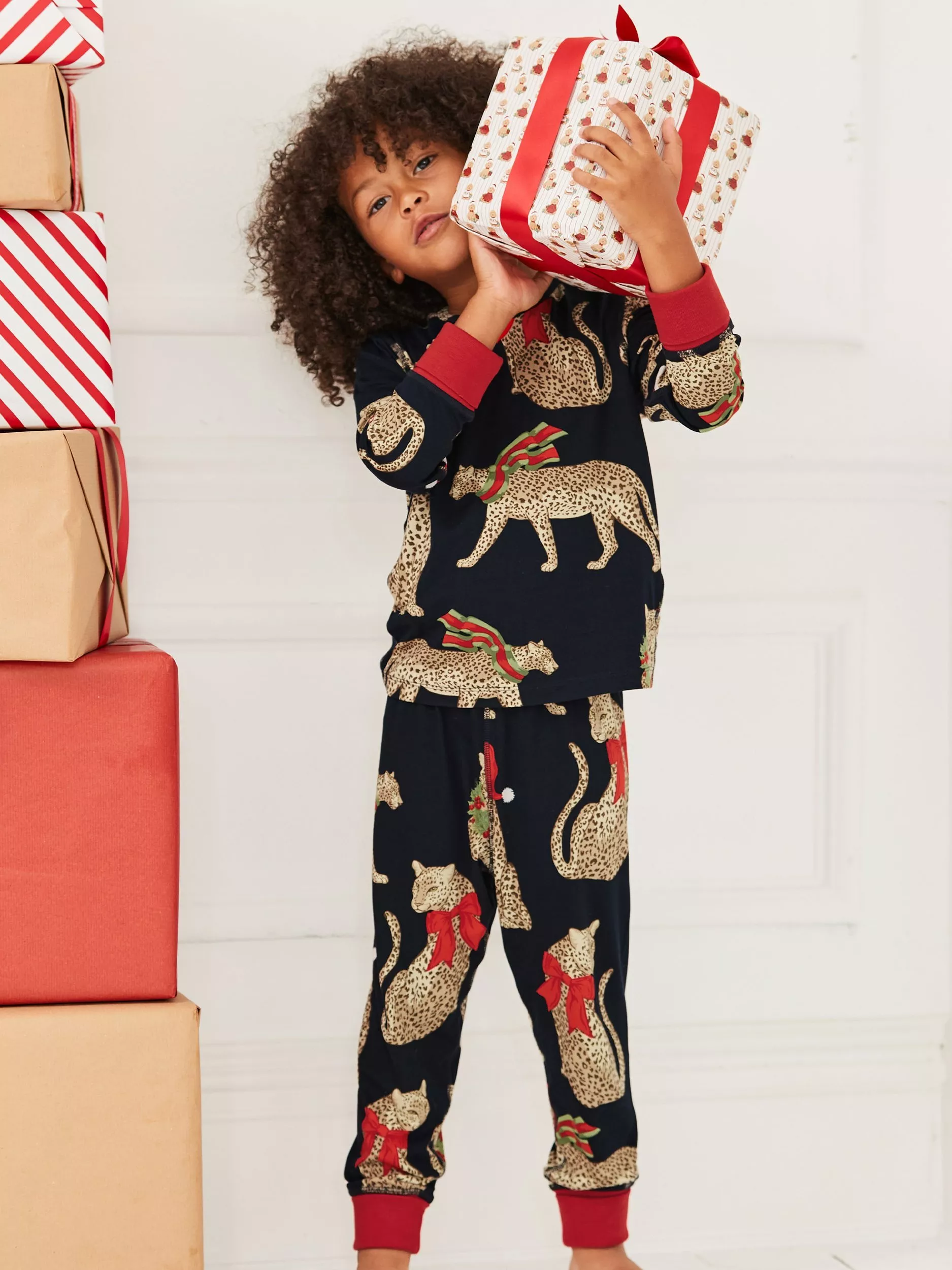 boy wearing a matching pyjama set with leopards on it