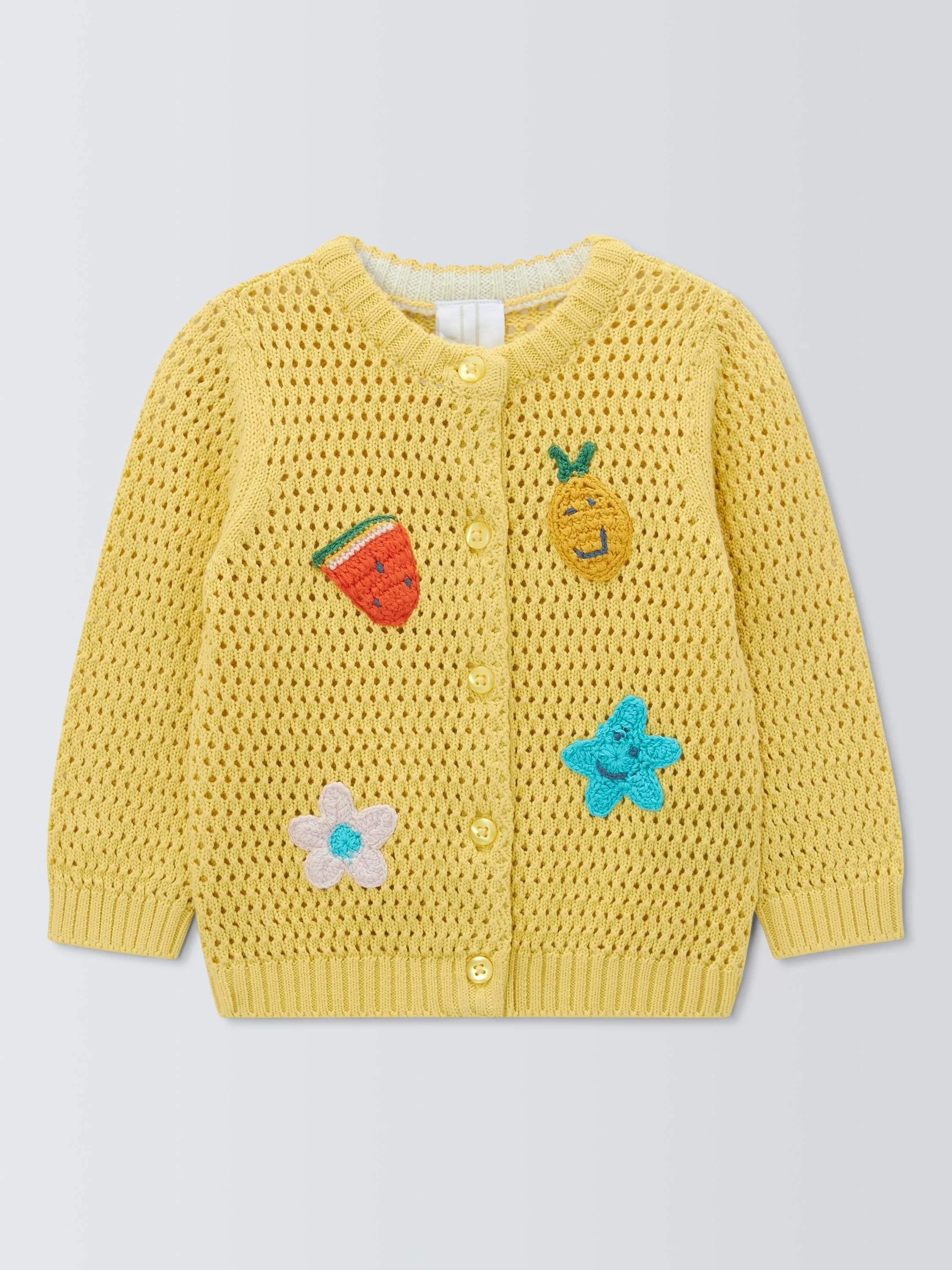 Yellow knitted baby cardigan with buttons and crochet fruit, flower and star patches on the front