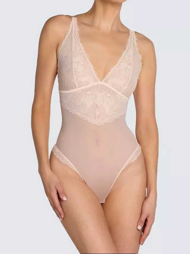 Blush pink lace and mesh bodysuit lingerie with deep V neckline, scalloped trim and high-cut leg on model