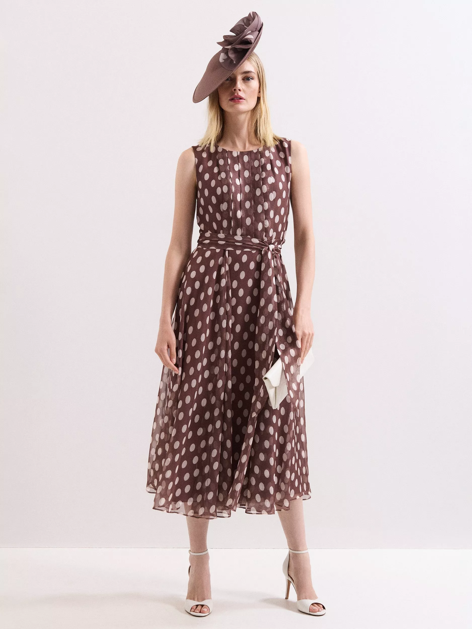 woman in brown polka dot dress with brown fascinator