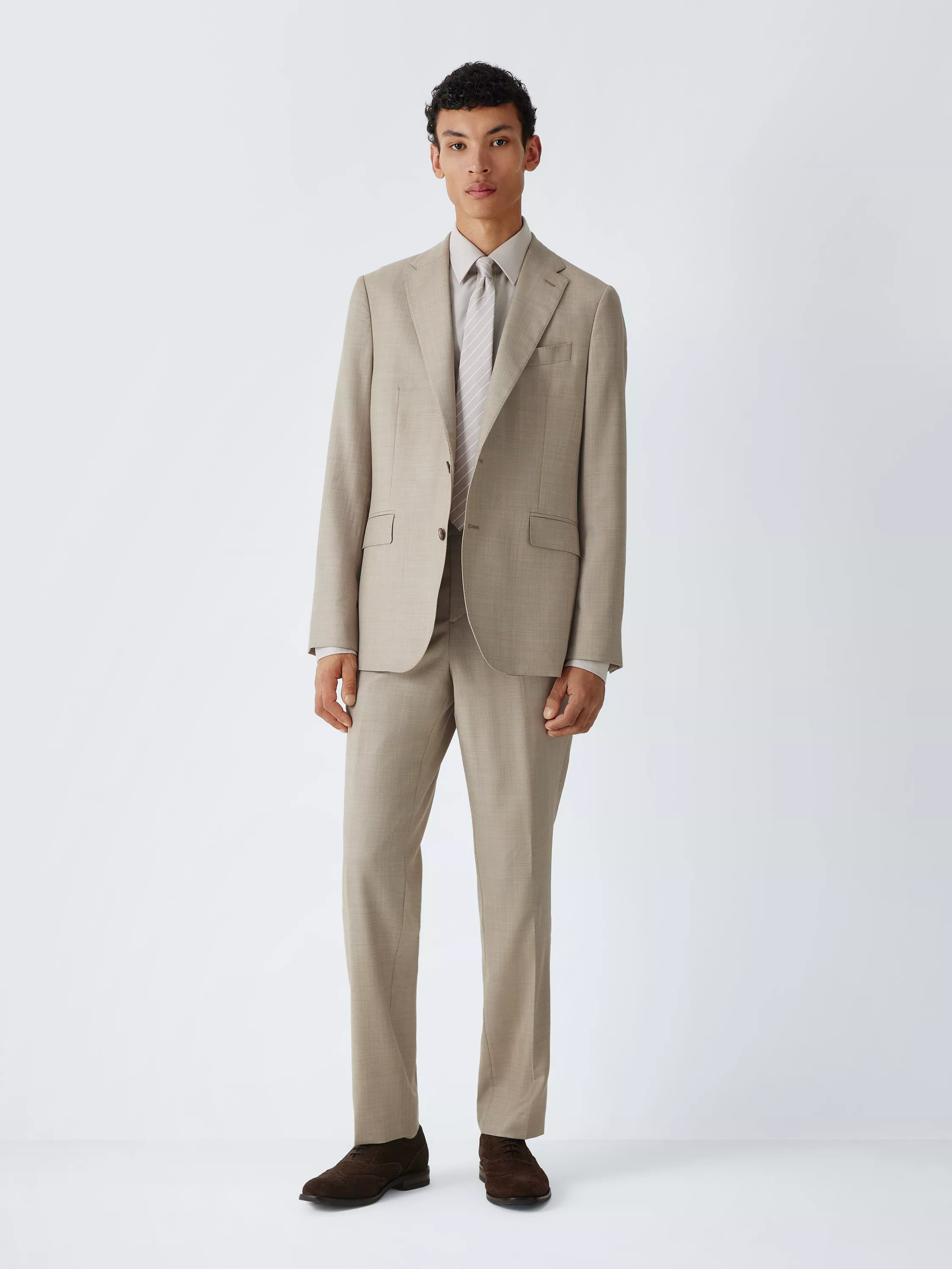 Male model wearing a charcoal grey two-piece suit with white shirt and blue patterned tie on a studio background
