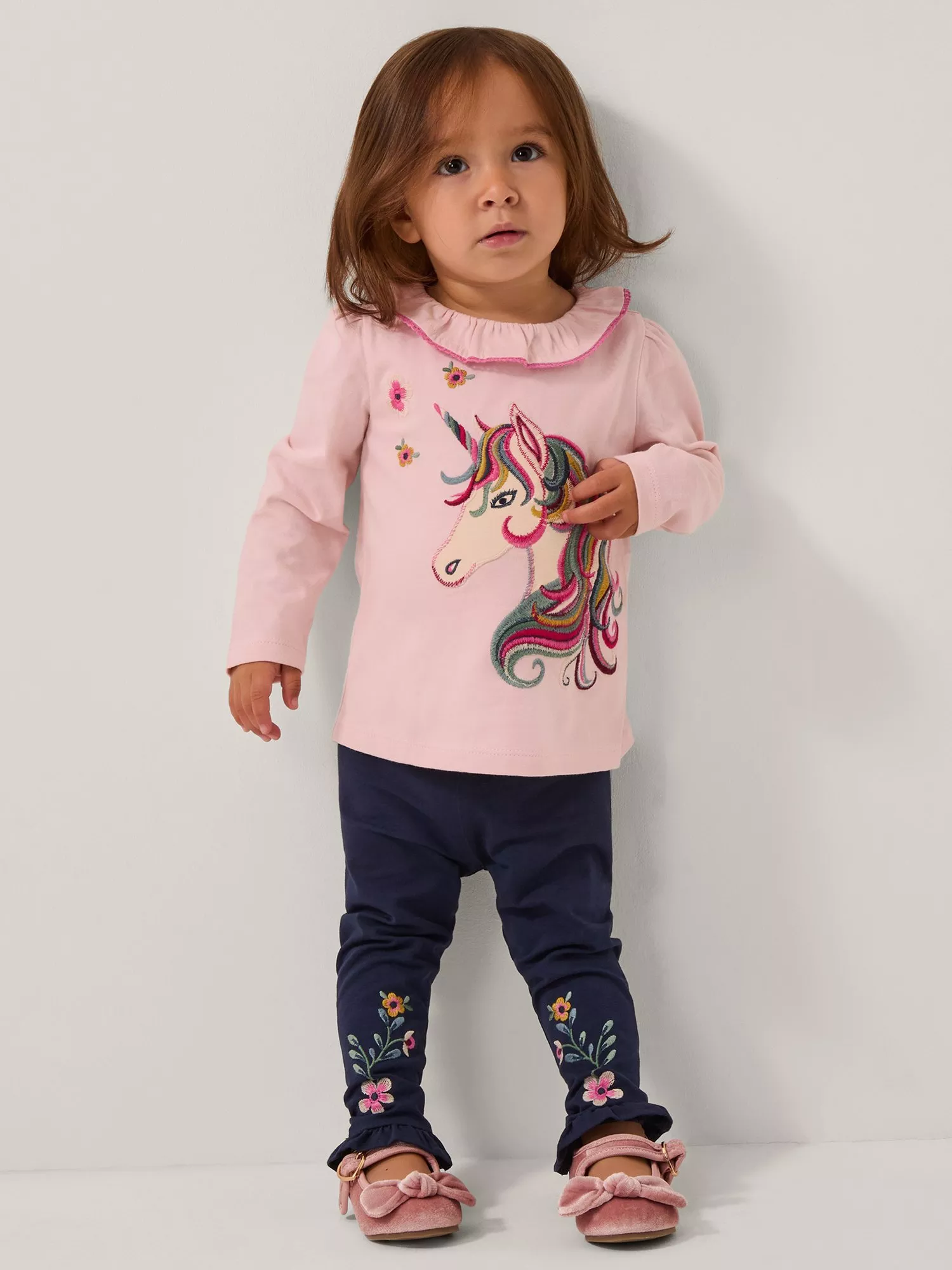 toddler girl wearing a unicorn top and trouser outfit set