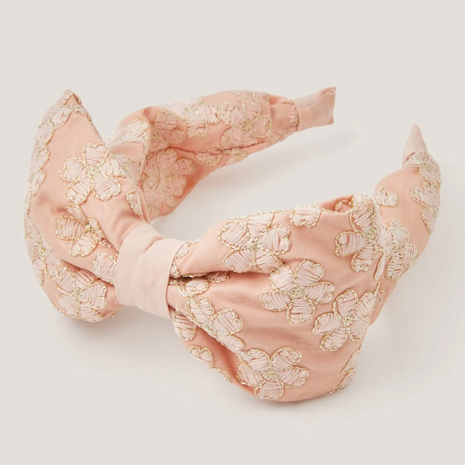 Pink embroidered floral knot headband with gold thread detailing, elegant women’s hair accessory on white background