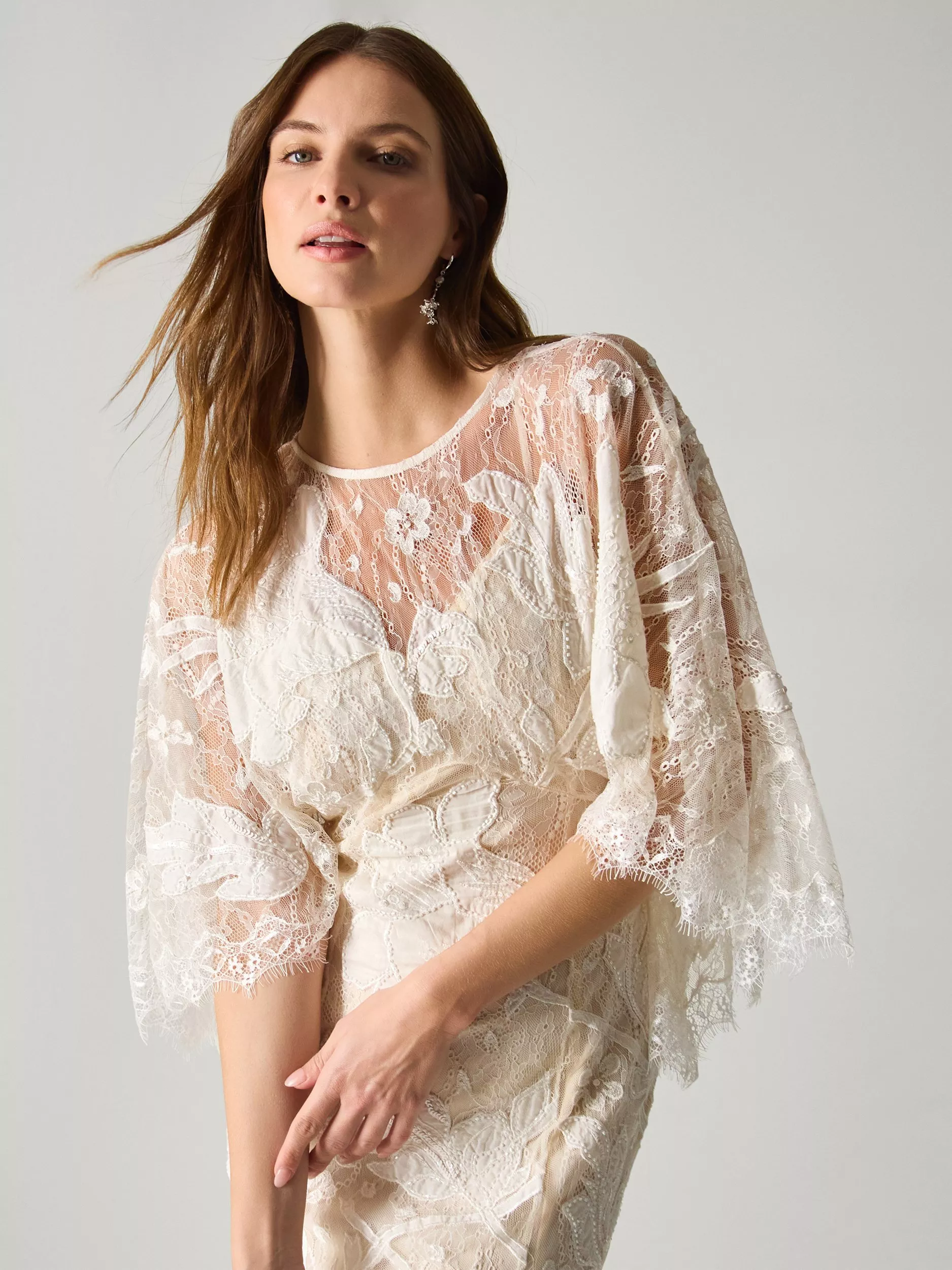 A woman wearing an ivory floral lace wedding dress