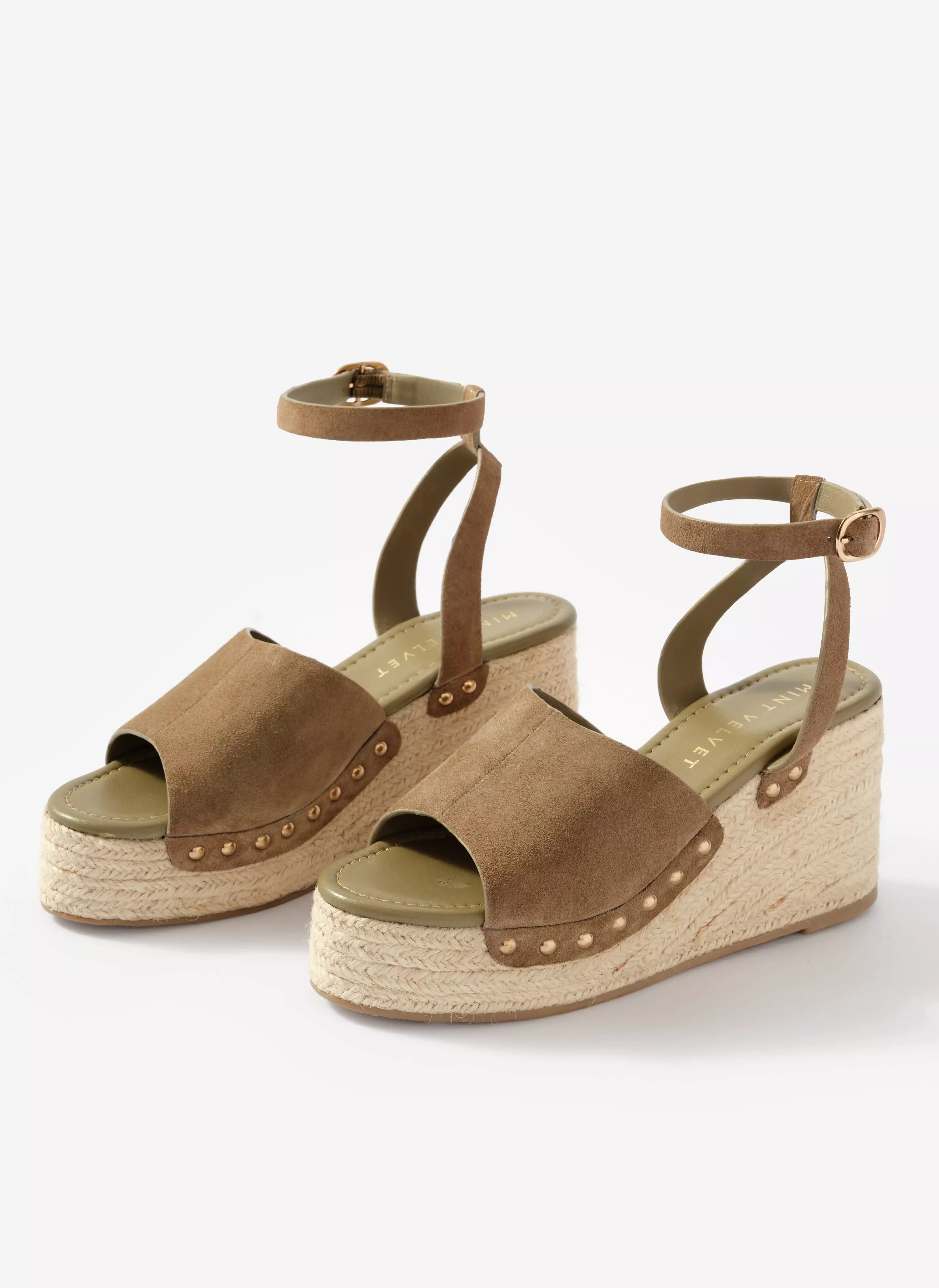 Tan suede wedge espadrille sandals with ankle straps, stud detailing and braided jute platform sole on white background