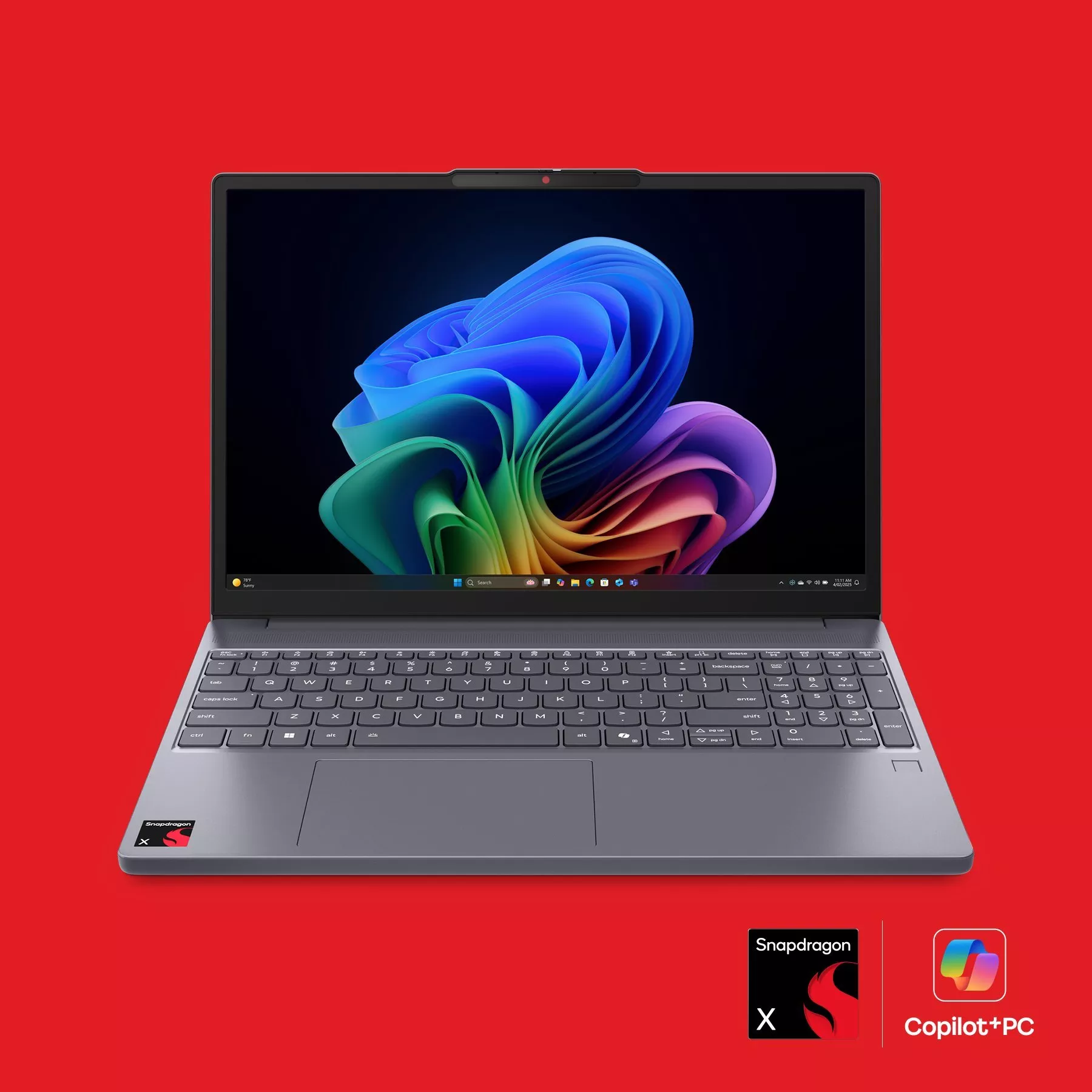 A sleek grey laptop with a colourful display on a red background, featuring Snapdragon and Copilot+PC logos.