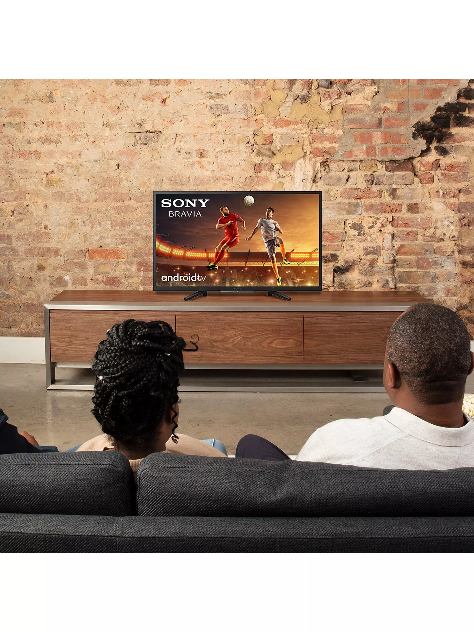 Samsung The Frame 2025 QLED TV displaying artwork in a modern living room, framed design with stand legs