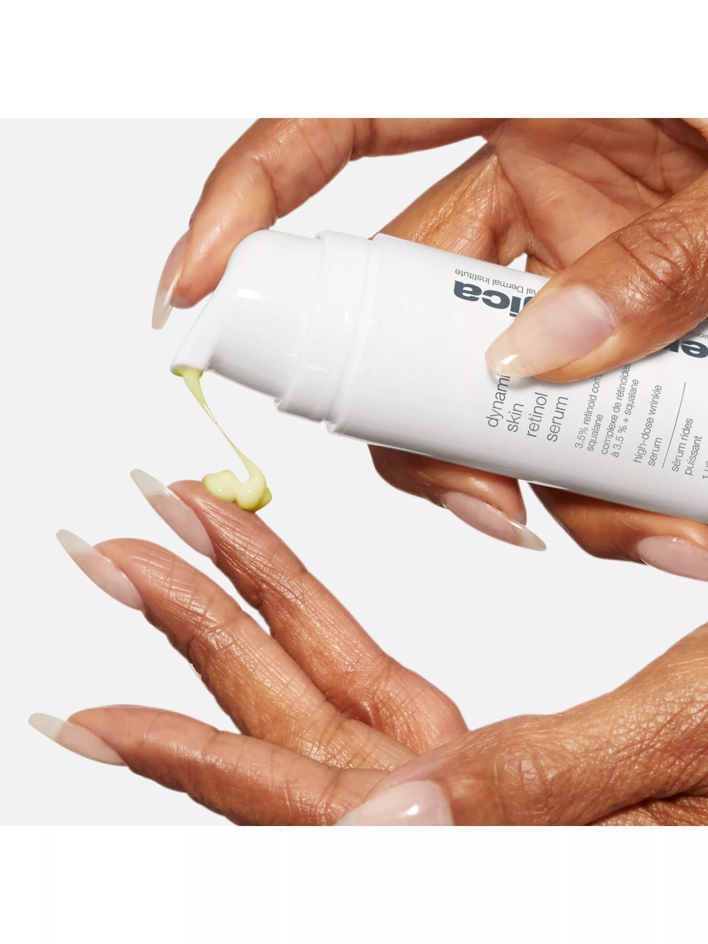Close-up of hands dispensing Dermalogica Dynamic Skin Retinol Serum from pump bottle onto fingertip.