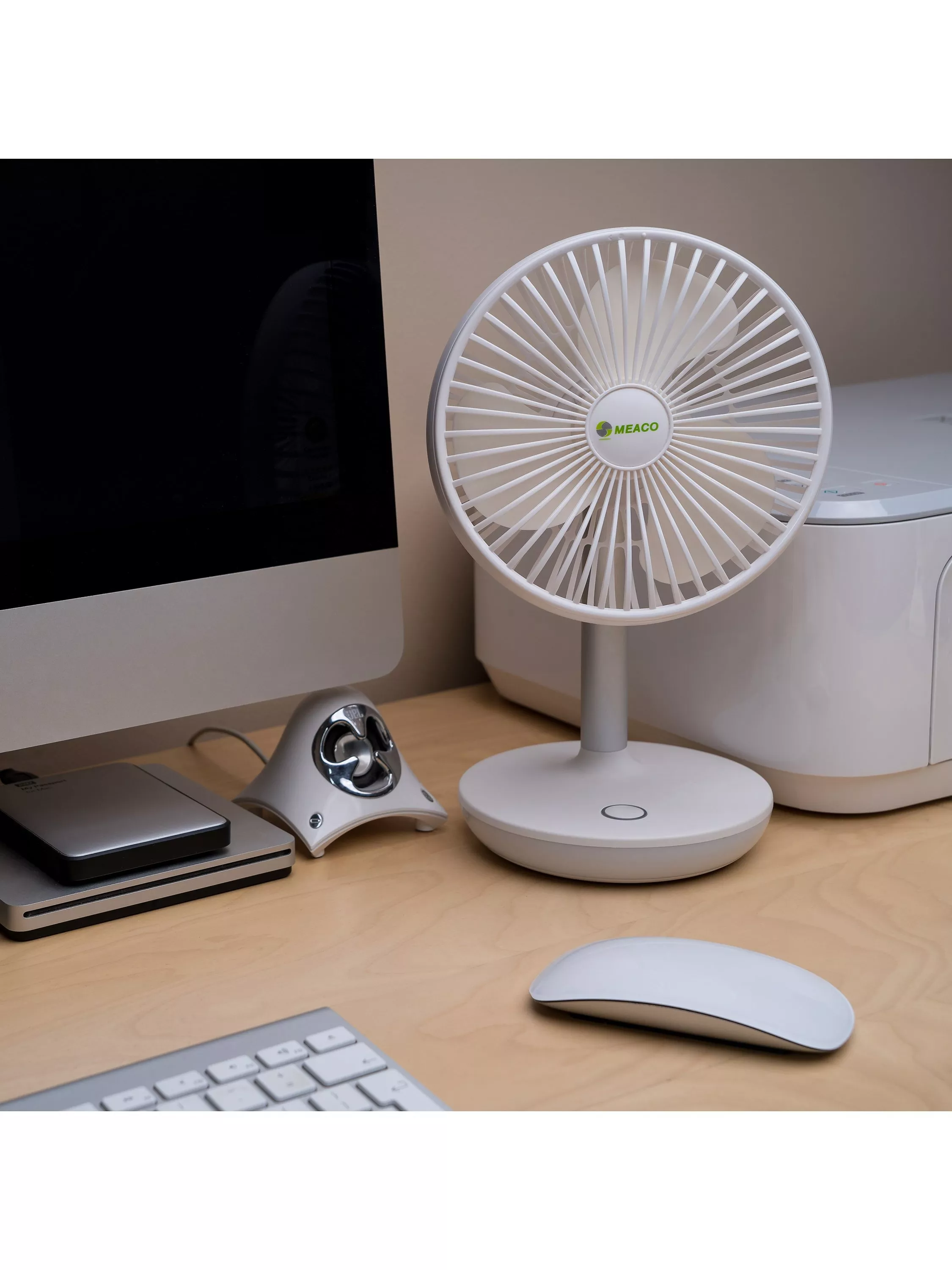 A white desk fan with a circular design sits on a wooden surface, featuring a modern and sleek appearance.