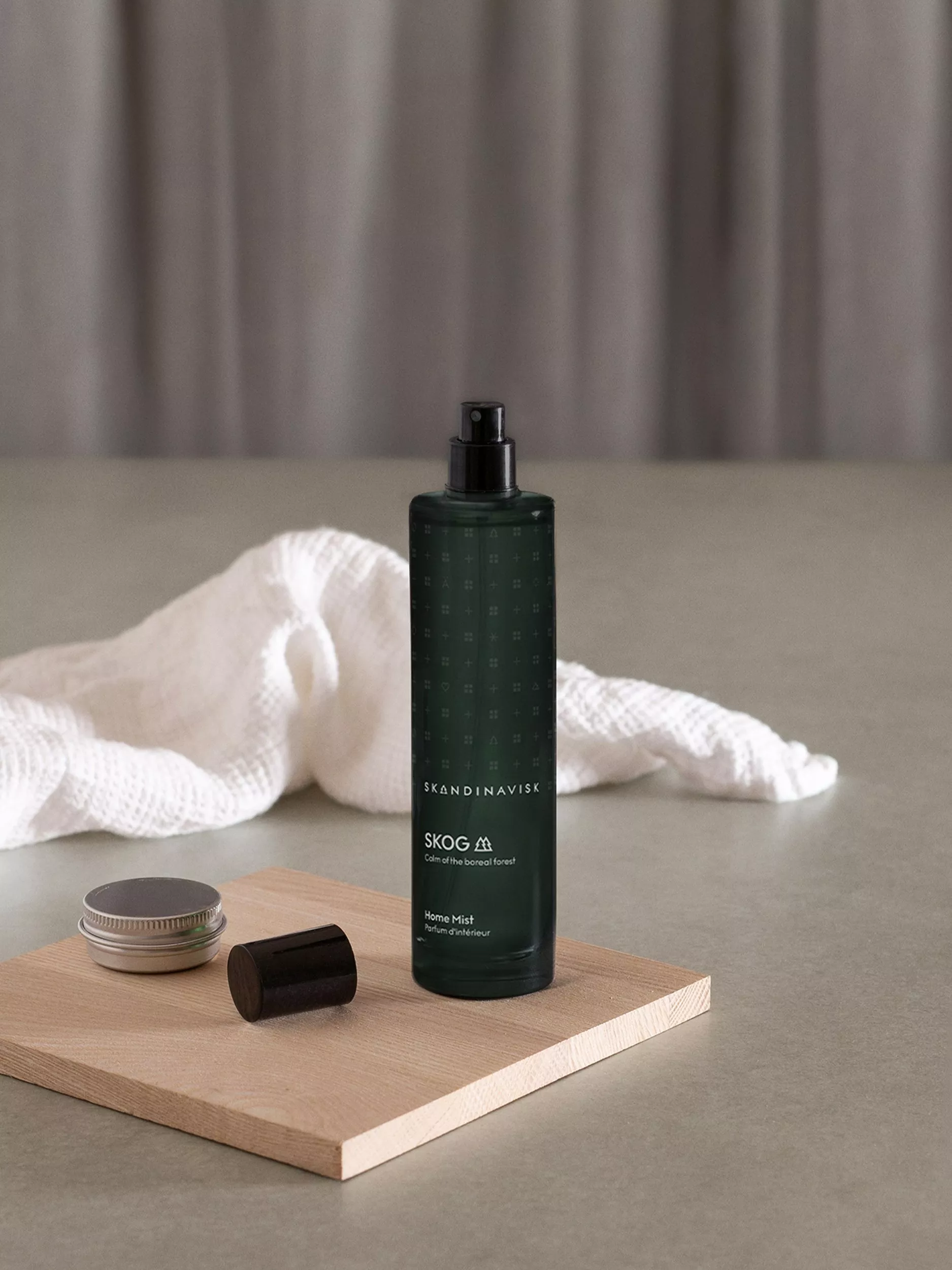 Room spray on a book beside reading glasses