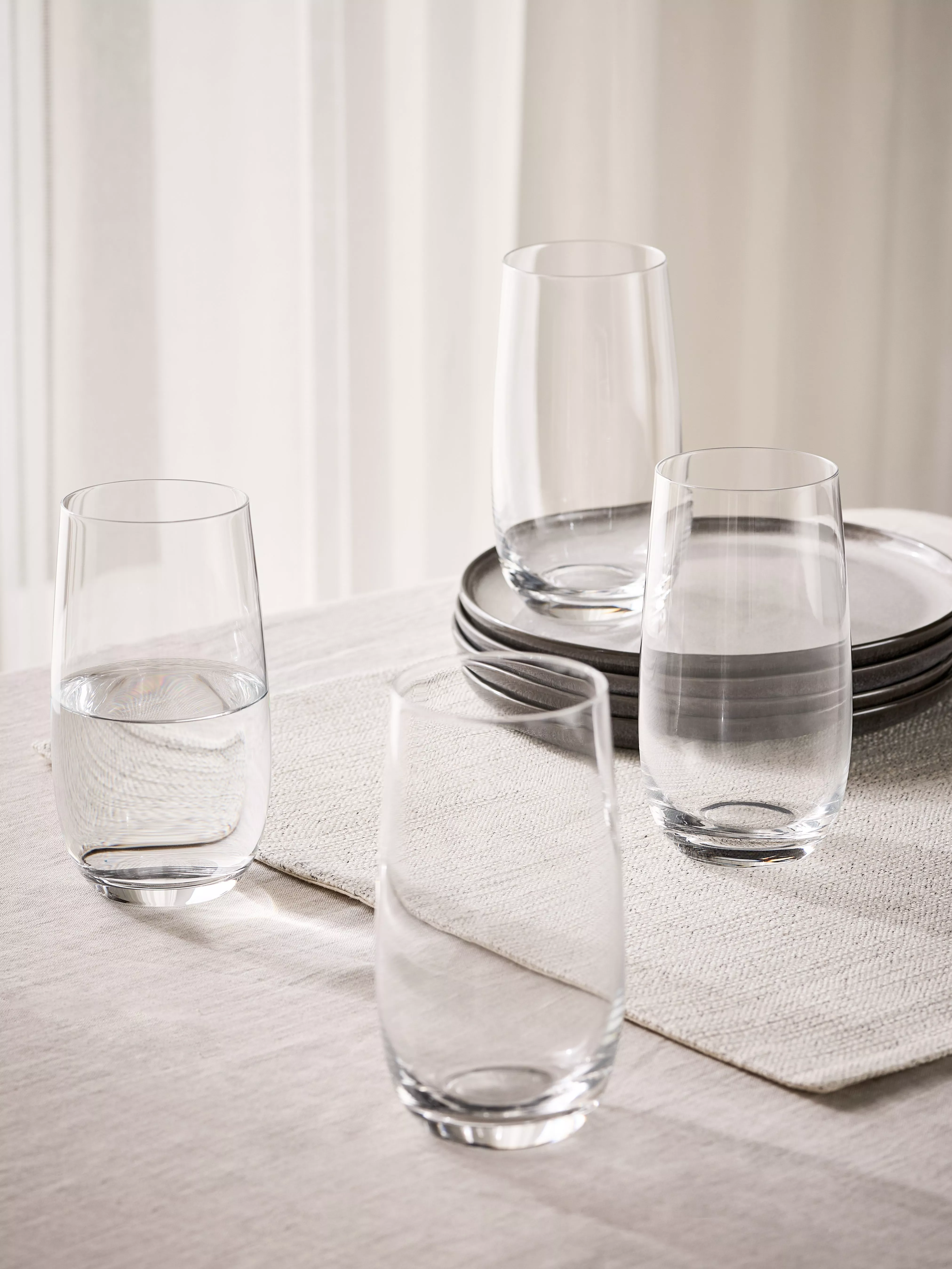 Tall water glasses out on a table 