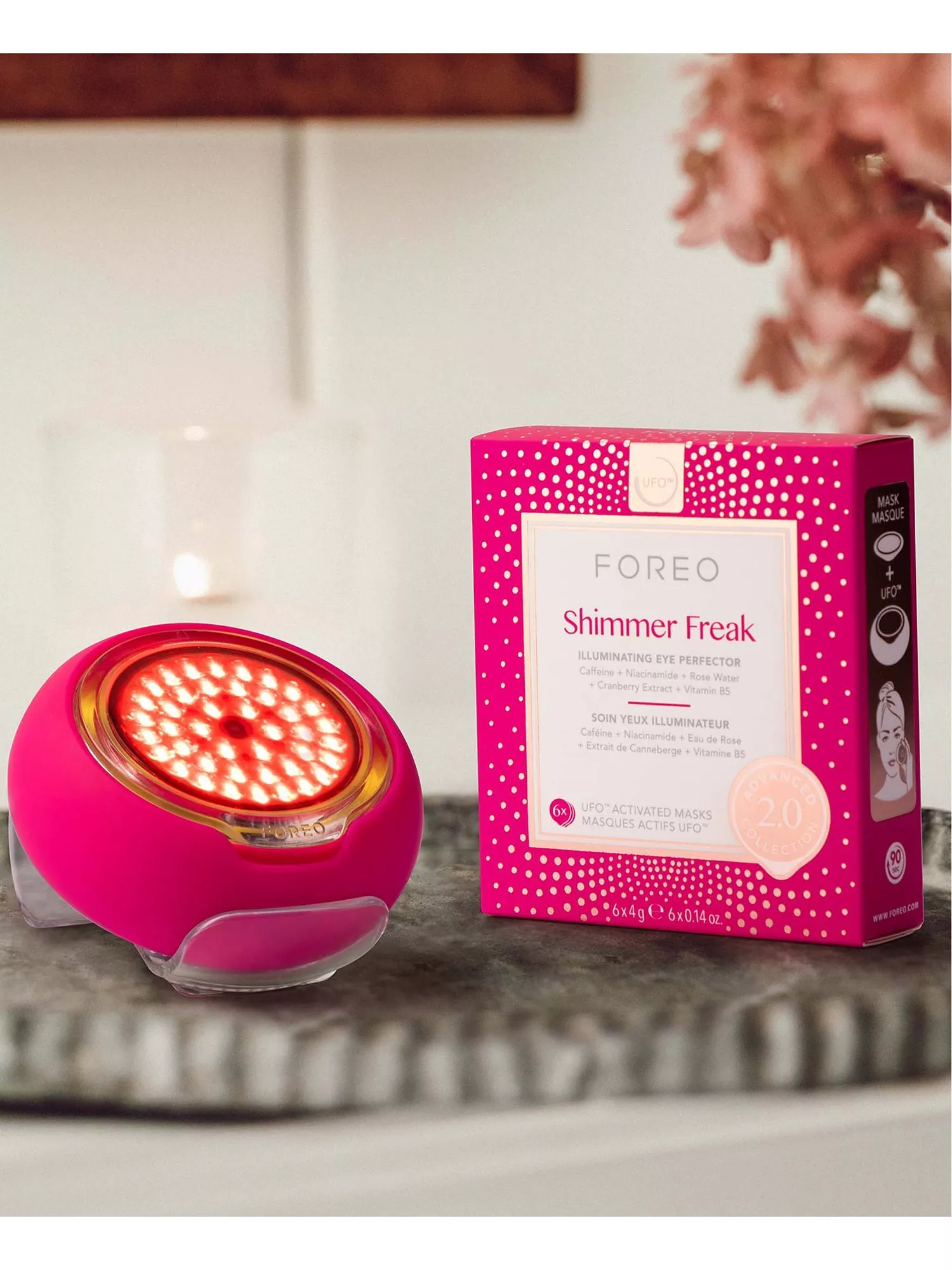 FOREO UFO 2 LED skincare device with Shimmer Freak illuminating eye mask box on marble bathroom counter