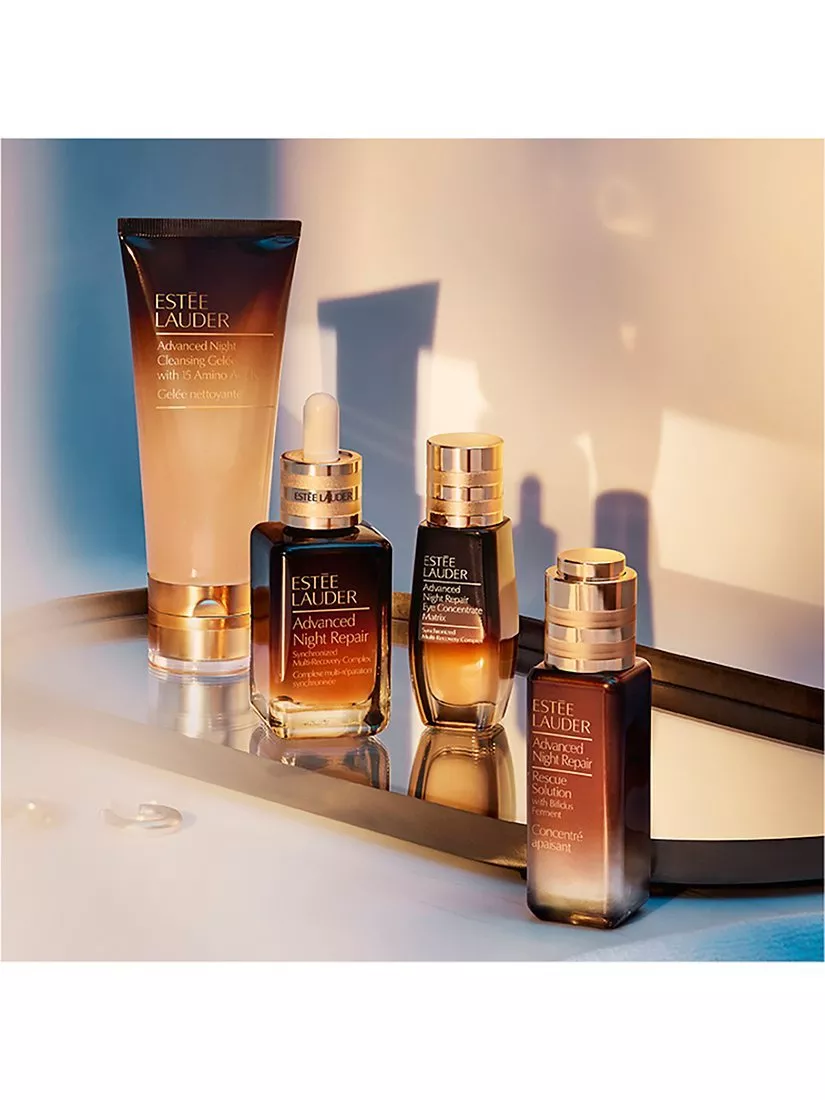 Estee Lauder skincare products, including cleansers and serums, arranged elegantly on a mirrored surface.