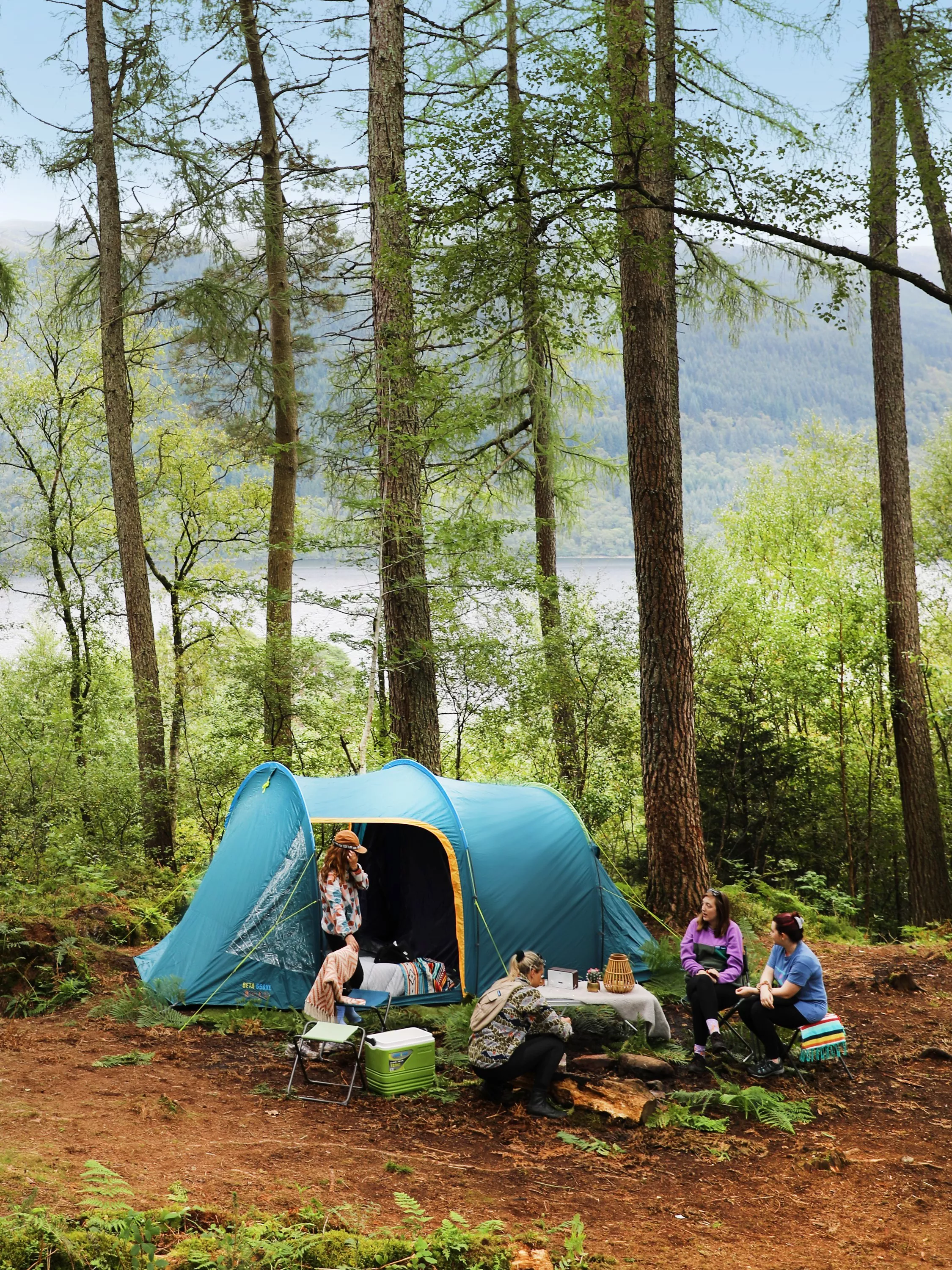 group outside a camping tent in a forest