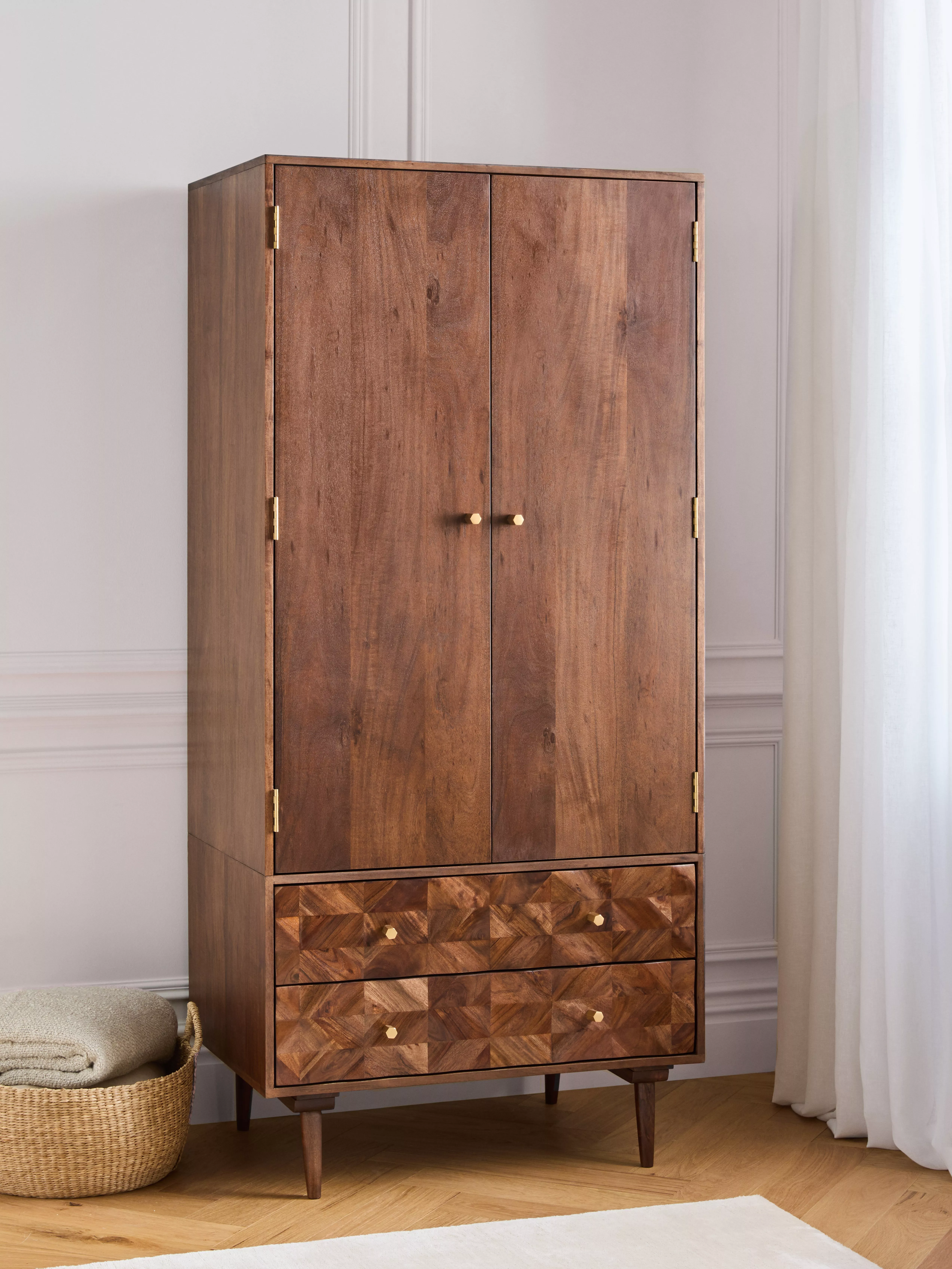 Wooden wardrobe with shirts hanging up inside