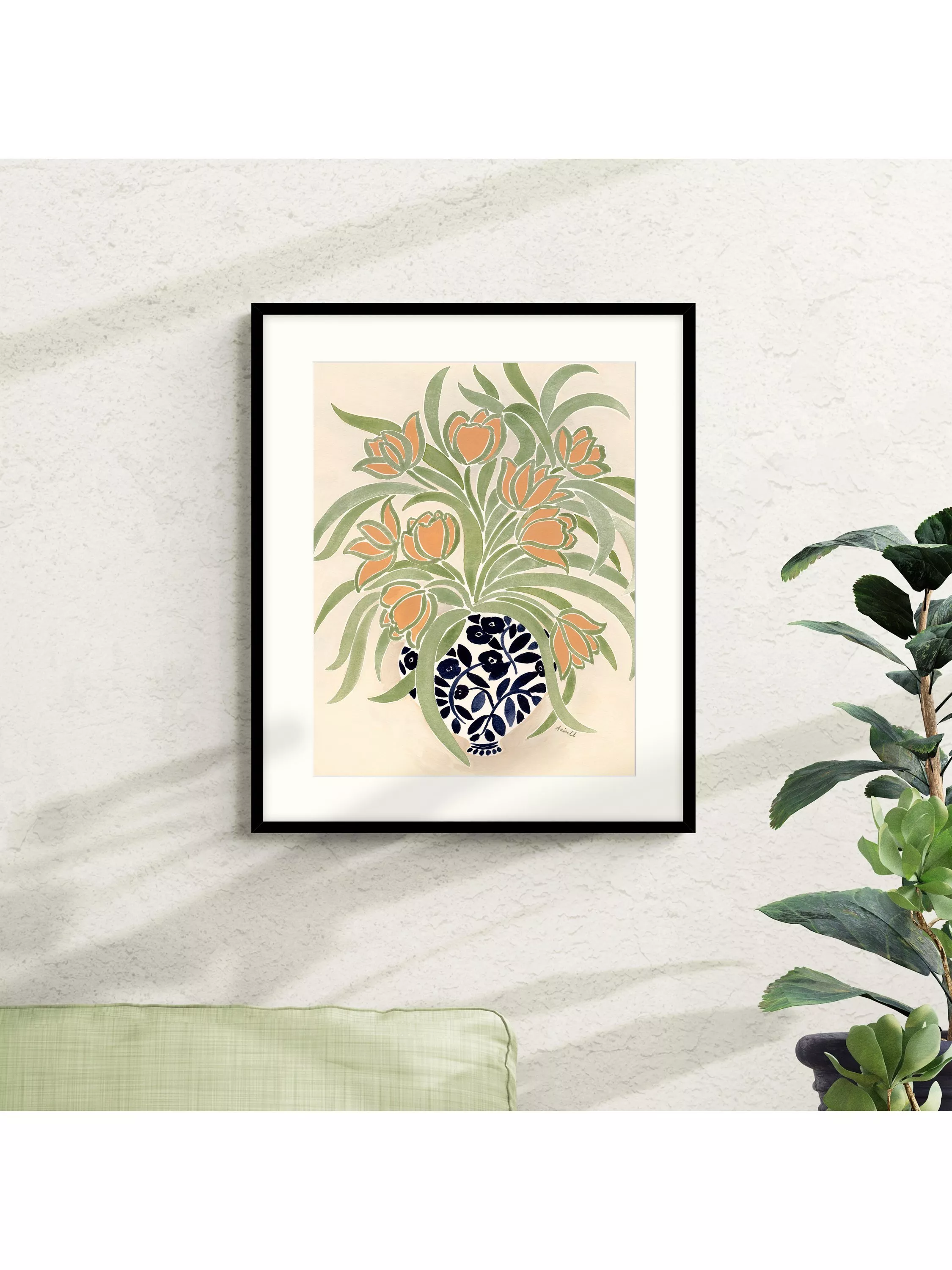 Framed floral wall art print with orange blooms and green leaves in a blue patterned vase on a textured wall