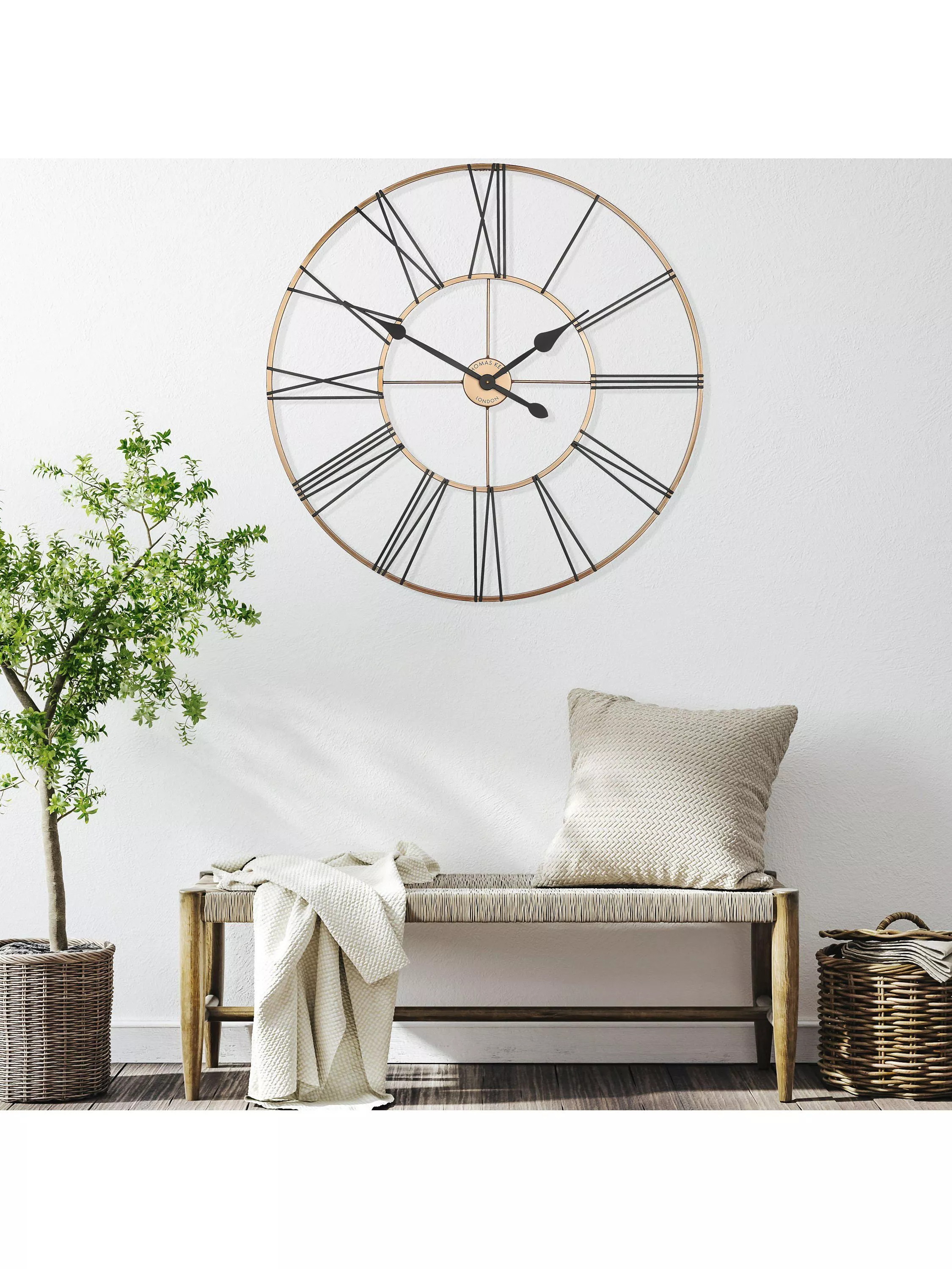 Large Newgate wall clock with wooden frame above modern home office desk and framed minimalist prints.
